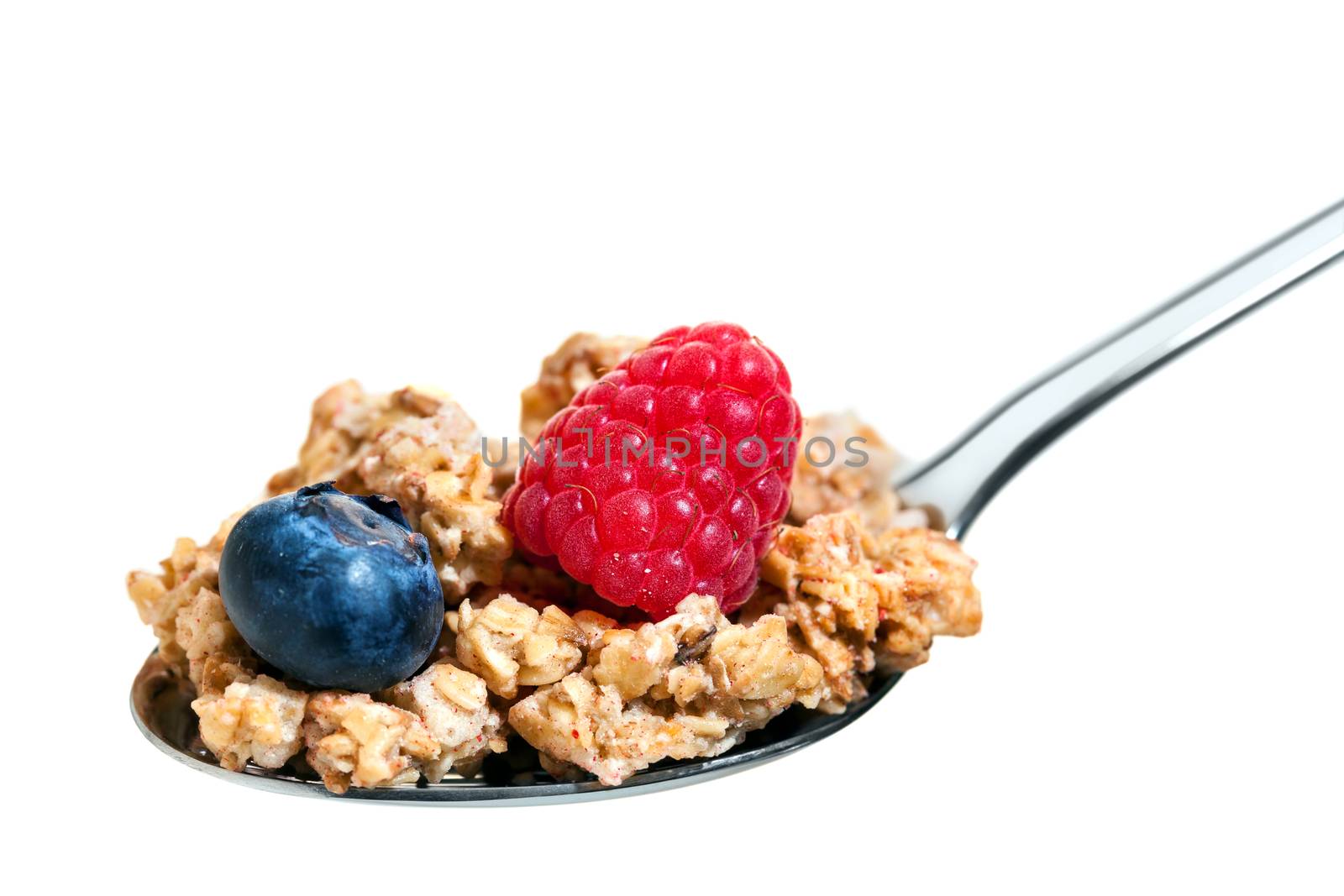 Macro close up of spoon with crunchy red fruit muesli.Isolated on white background.