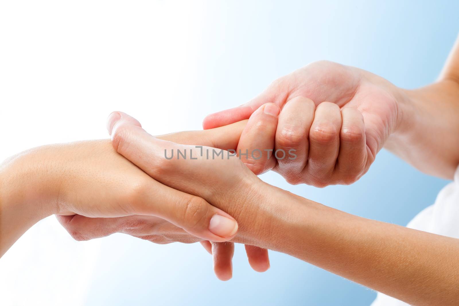 Macro close up of curative hand massage. Therapist manipulating female hand.