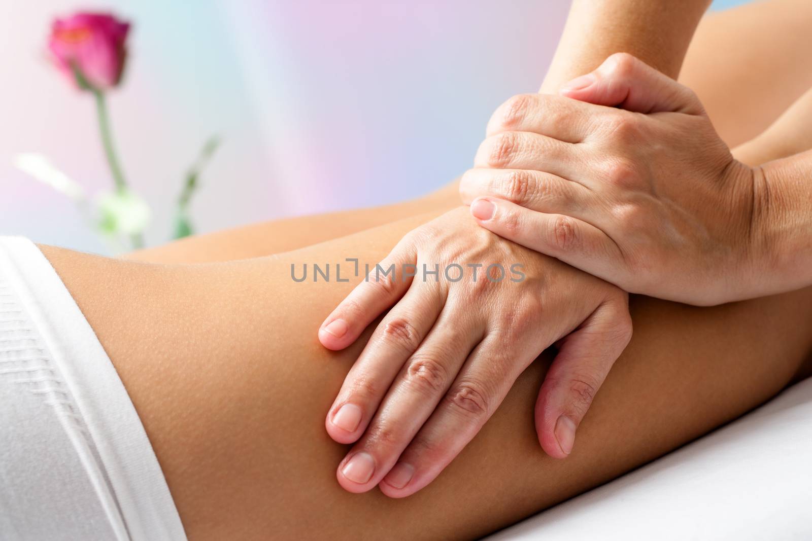 Close up Detail of Hands massaging female hamstrings. Therapist doing manipulative treatment on upper back leg.