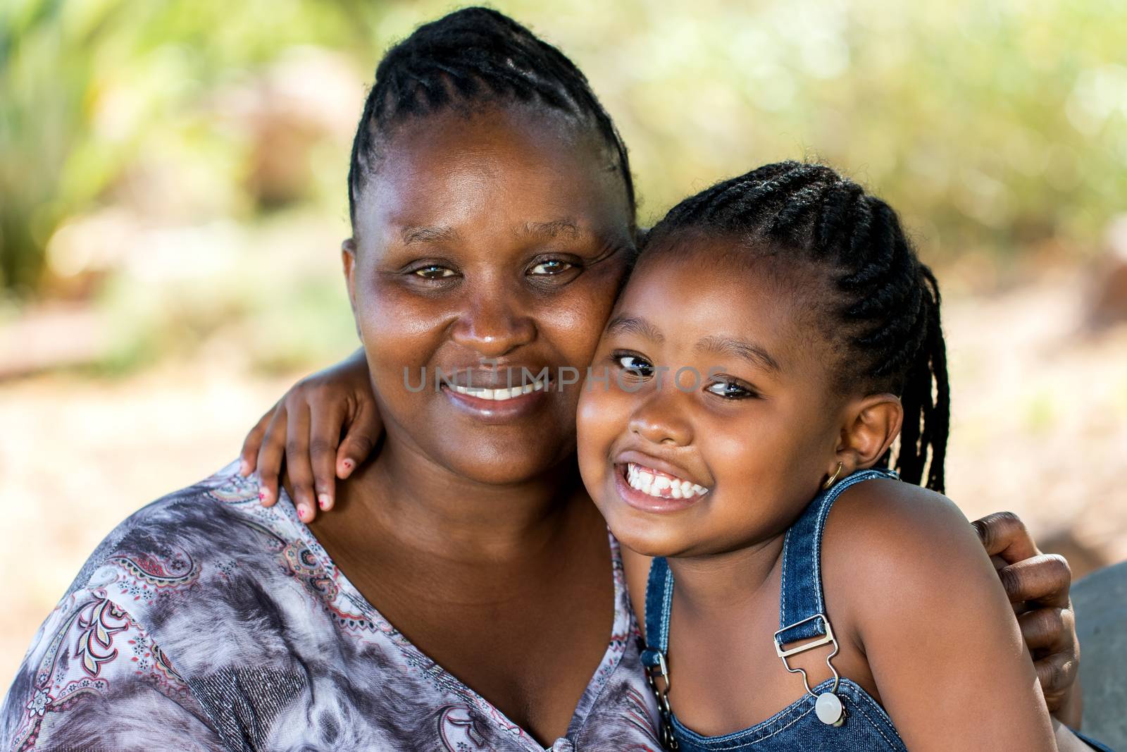 Close up portrait of Cute african mother and child embracing outdoors.