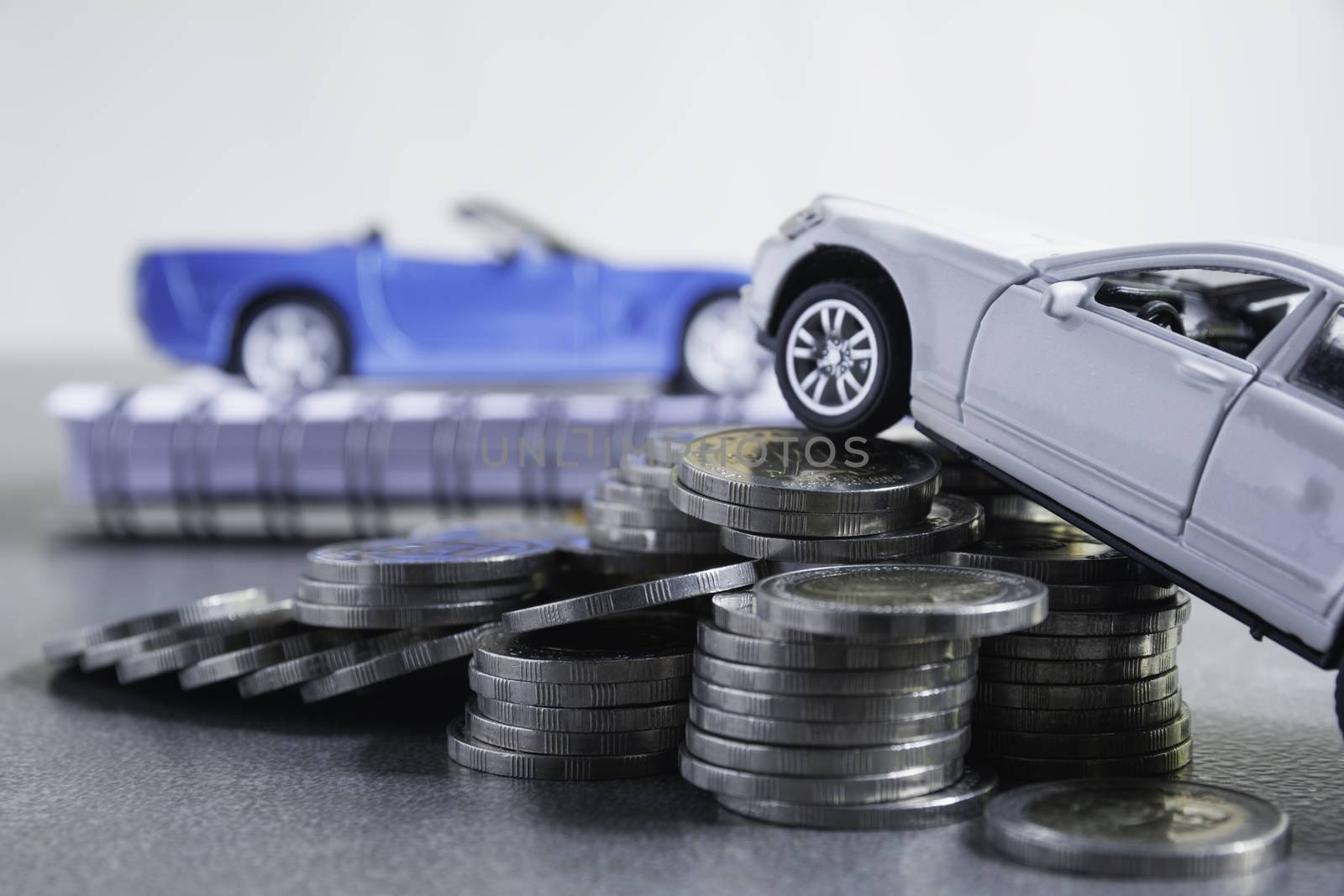 Car insurance and car service with stack of coins. Toy car for accounting and financial concept.