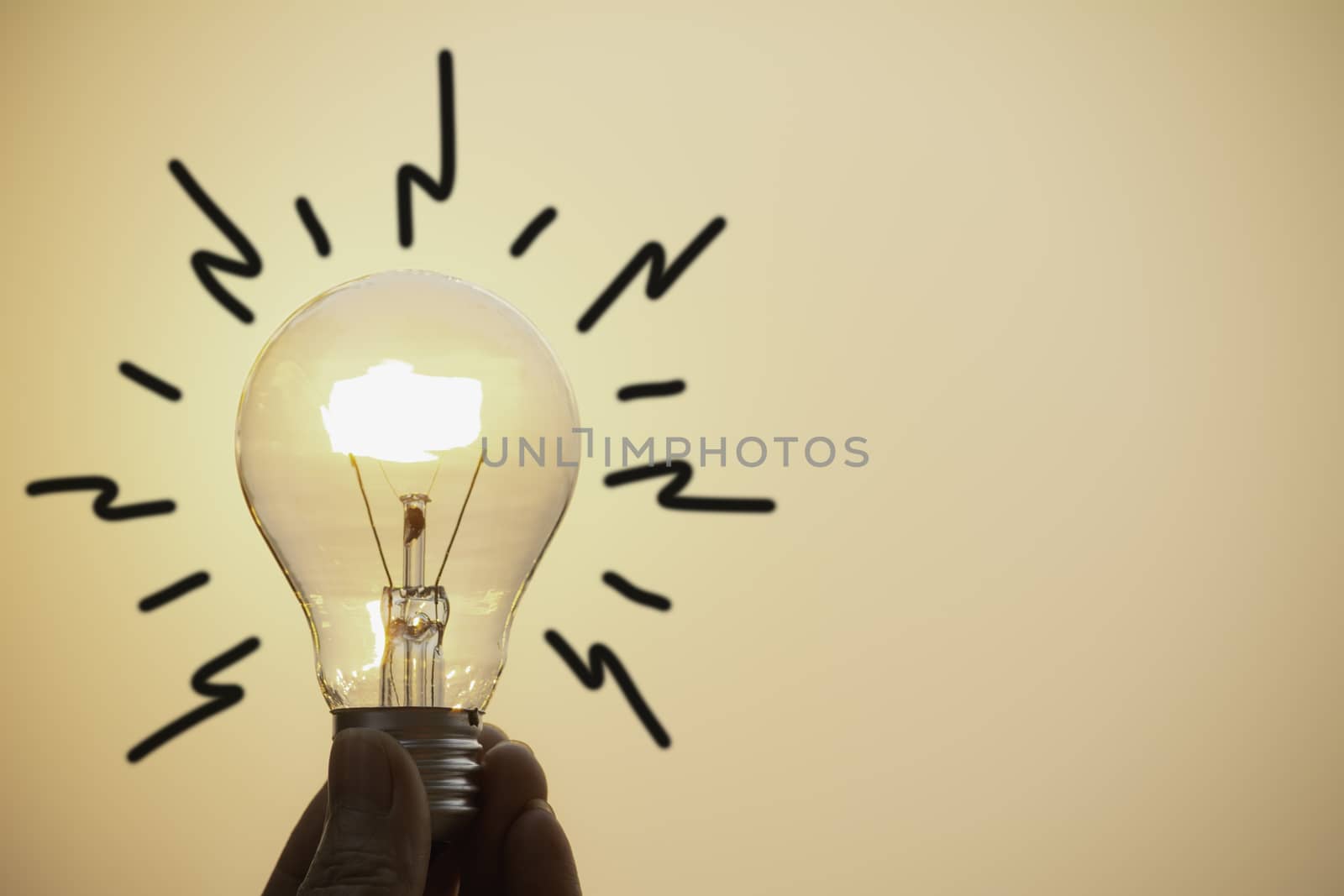 Hand hold a light bulb on sunset background for saving energy and creative concept.