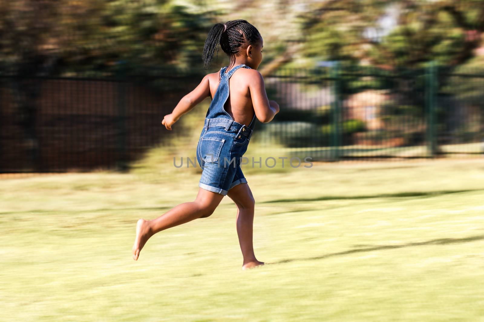Rear view of african kid running. by karelnoppe