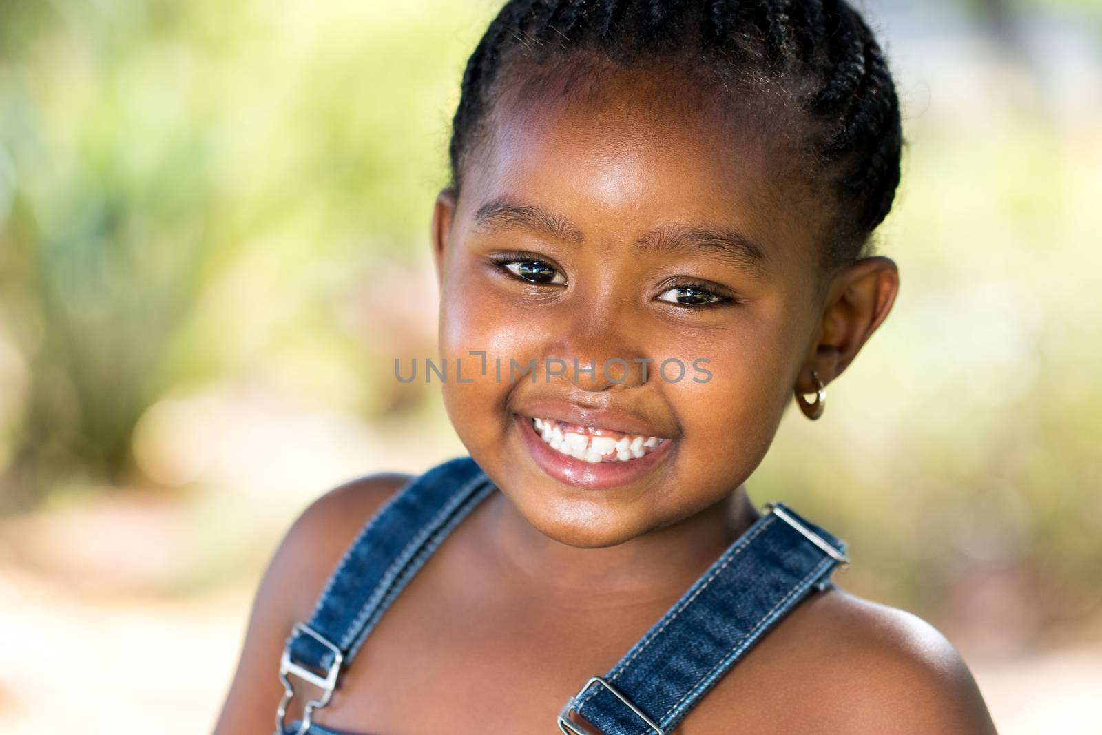 Close up face shot of cute Smiling african girl outdoors.