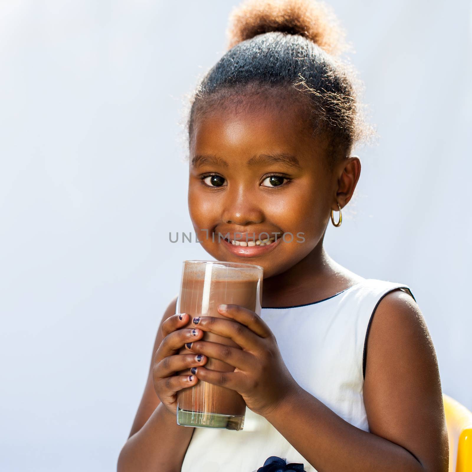 Cute african girl with milk chocolate drink. by karelnoppe