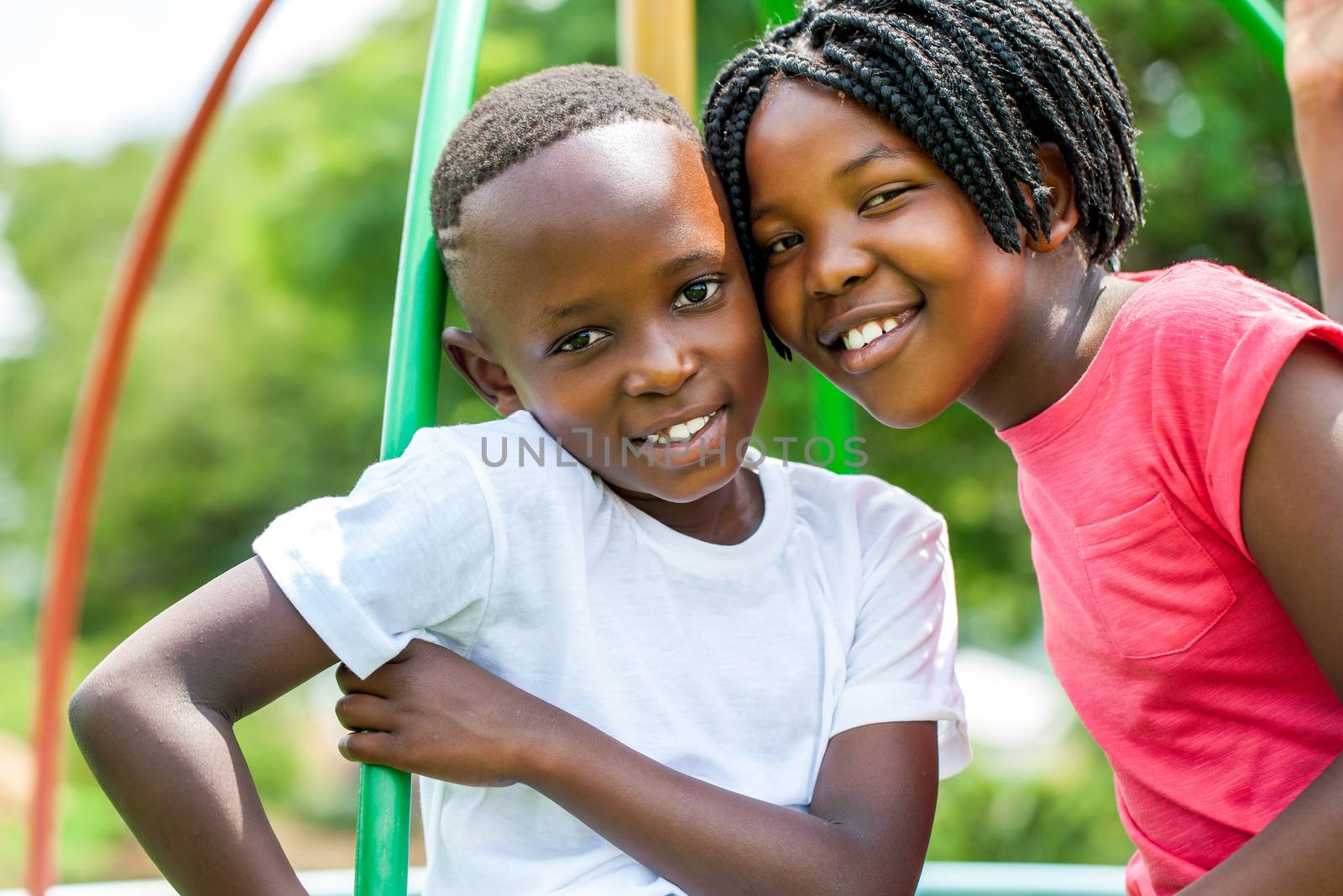 Close up face shot portrait of African kids joining heads in park.