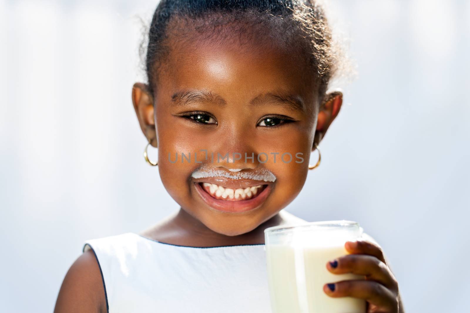 Cute african girl showing white milk mustache. by karelnoppe