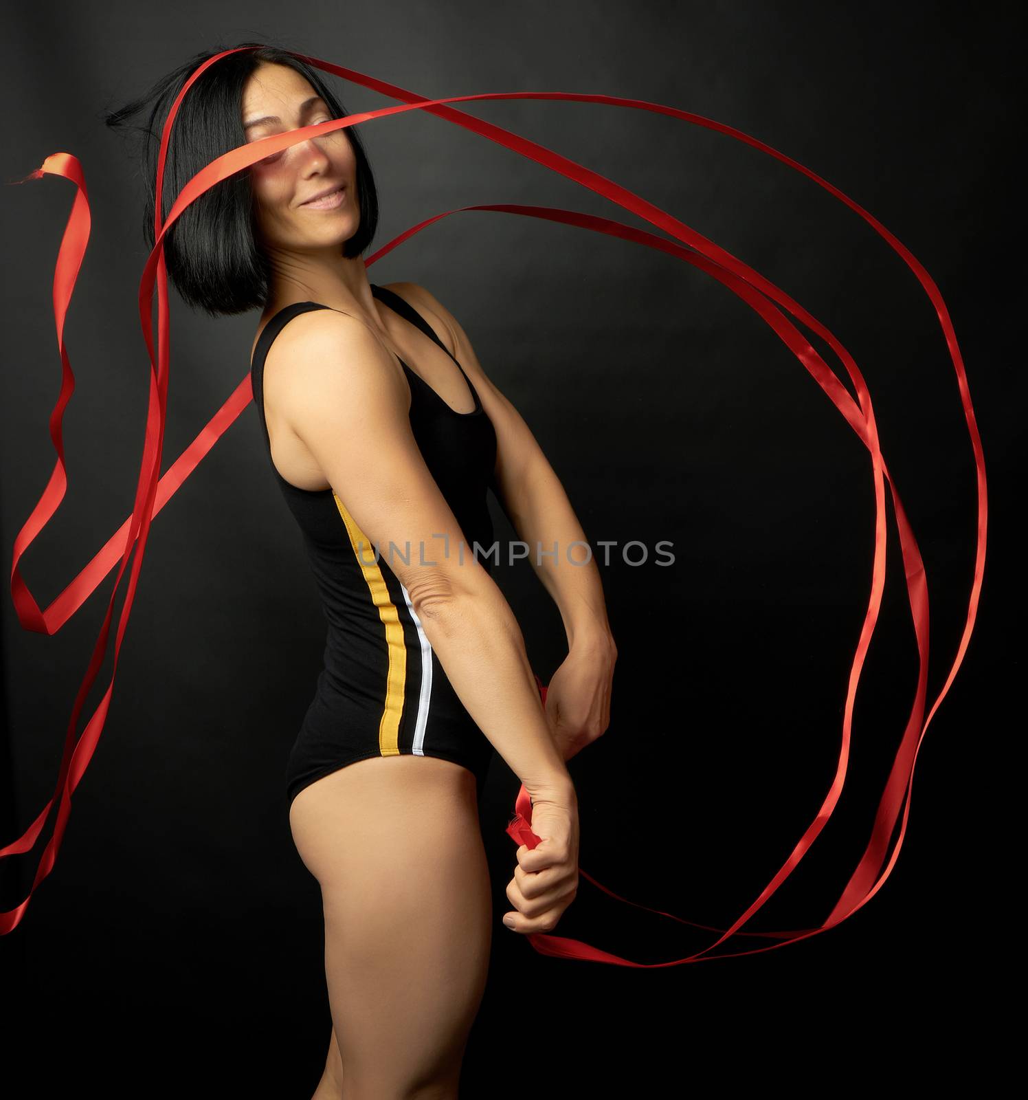 young woman gymnast of Caucasian appearance with black hair spin by ndanko