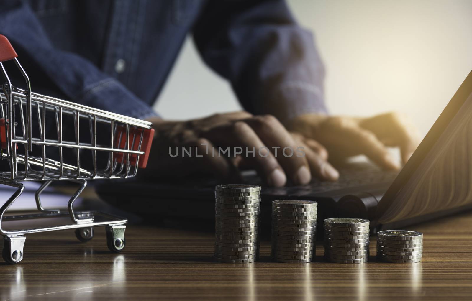 Businessman with money coin stack and shopping cart for financial and accounting concept.