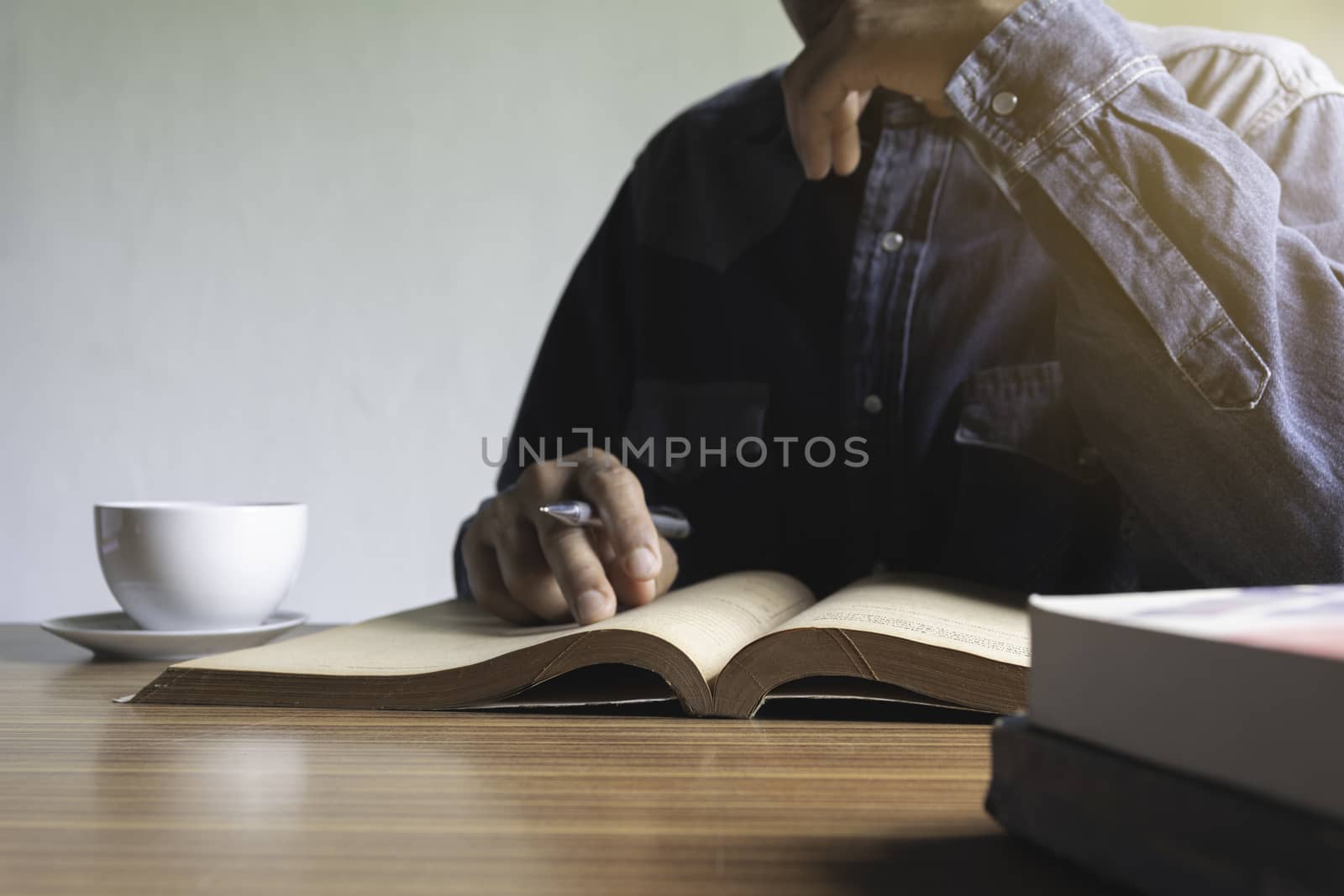 A Man reading a book enjoys of rest. Man sitting and reading a book. Concepts of rest, education and comfort.