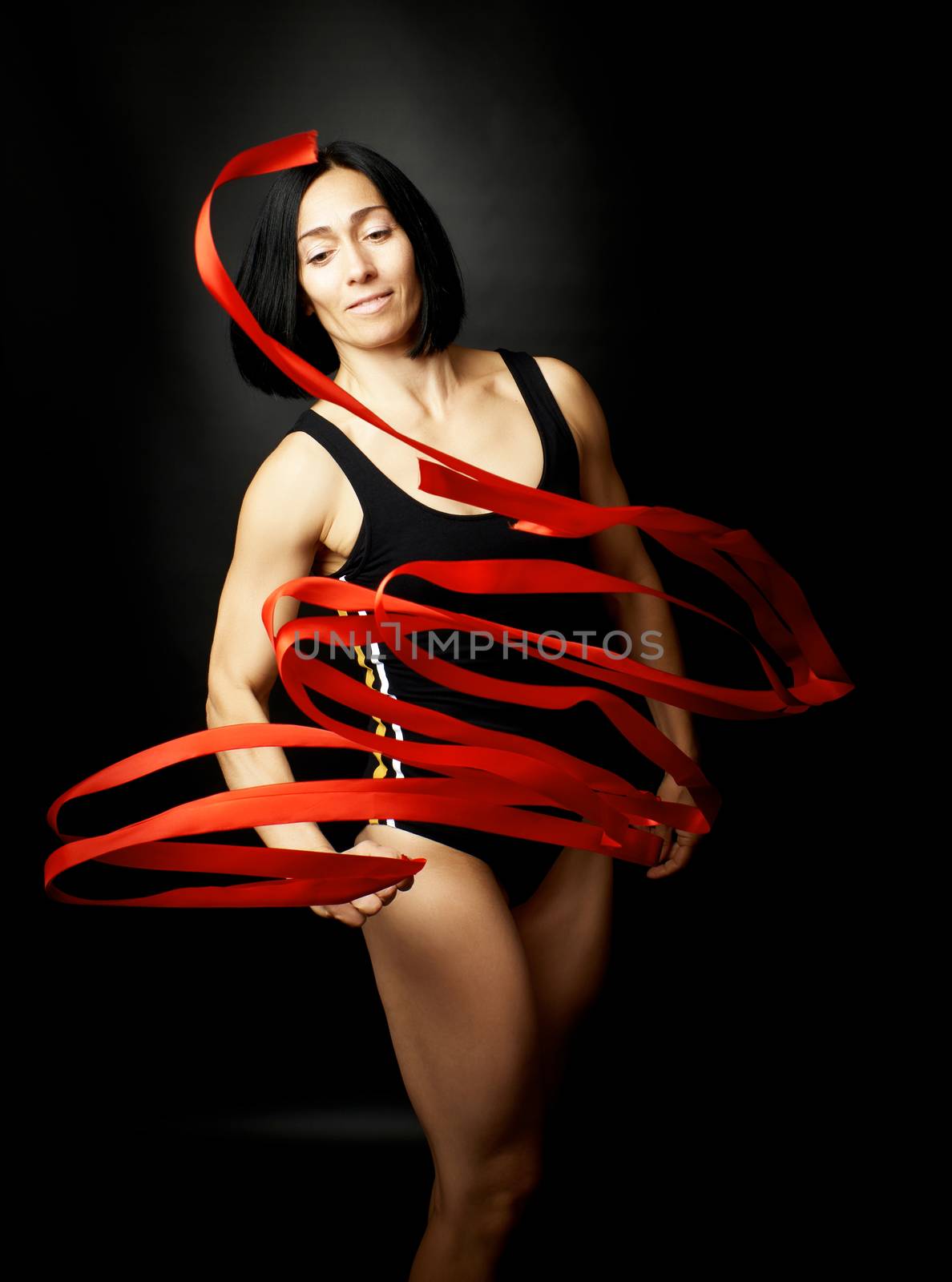 young woman gymnast of Caucasian appearance with black hair spin by ndanko