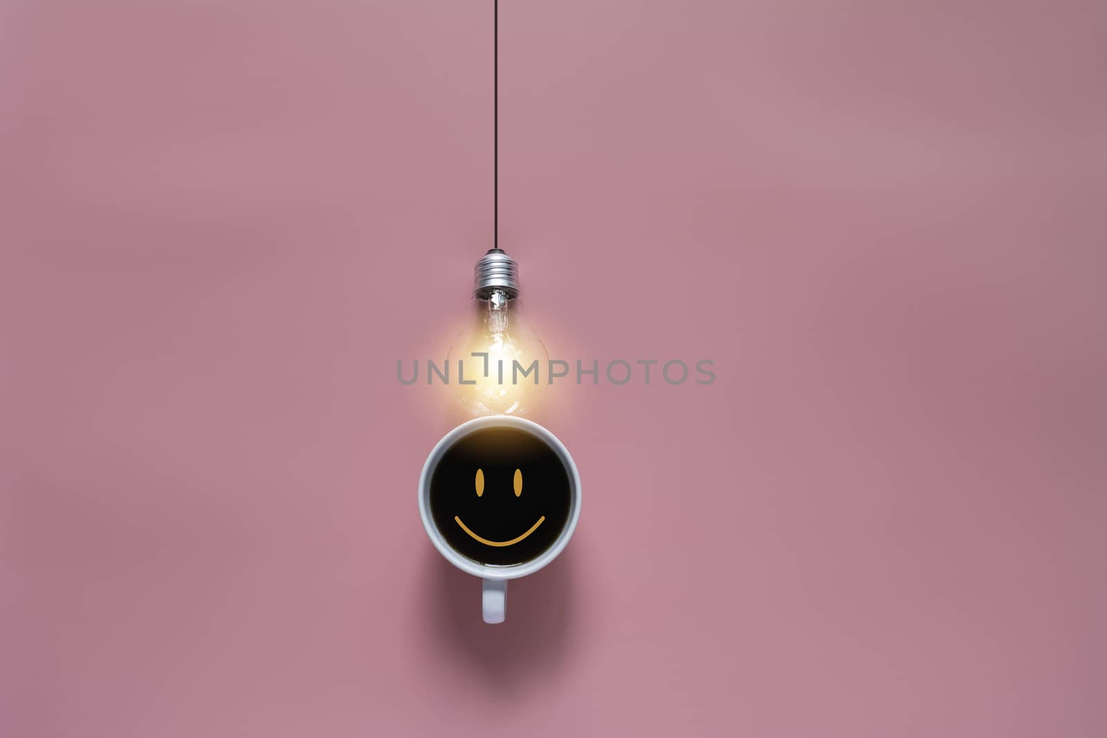 Top view of coffee with light bulb on pink background and copy space for insert text.