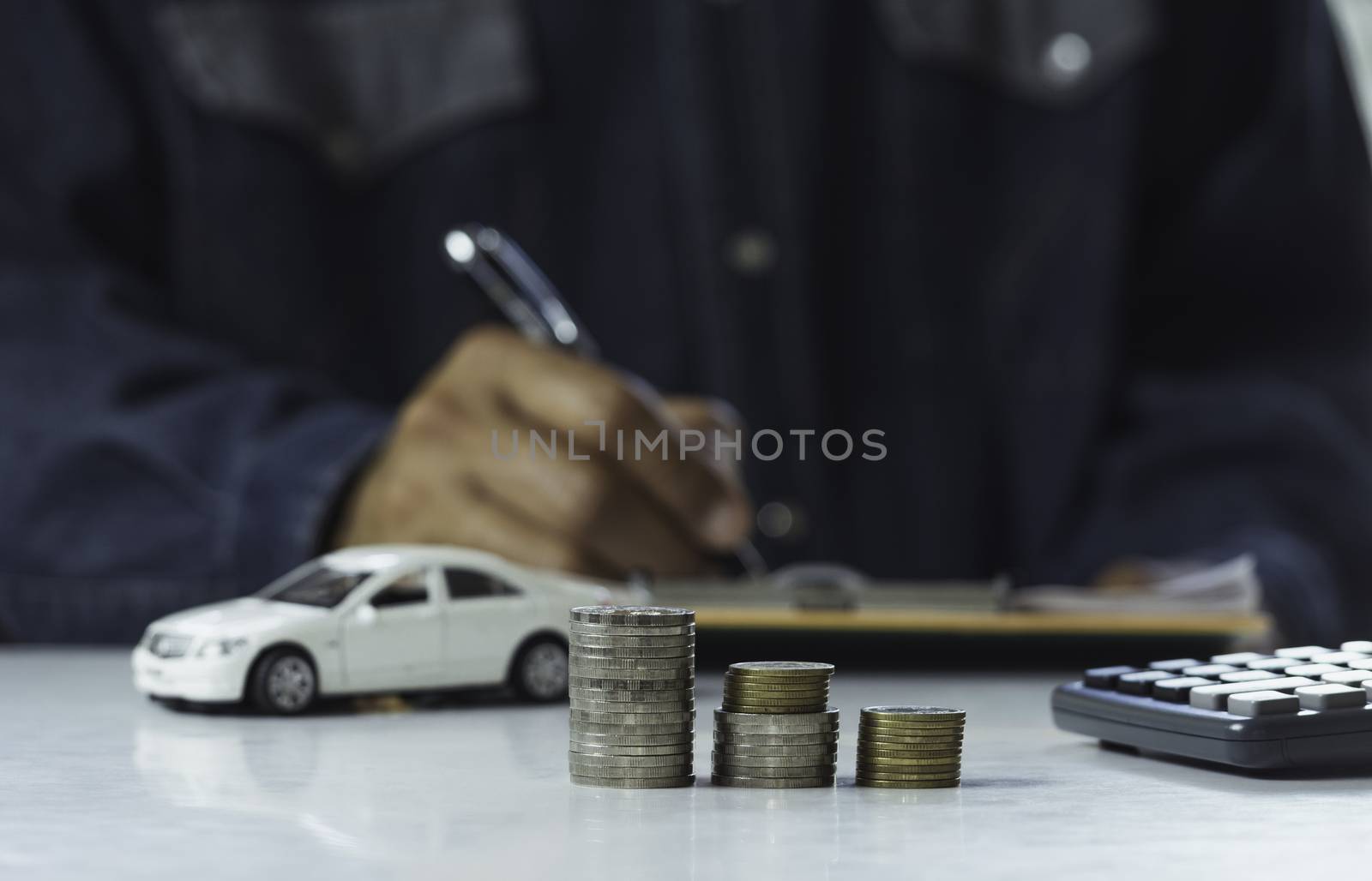 Car insurance and car service. Businessman with stack of coins and toy car, business and financial concept.