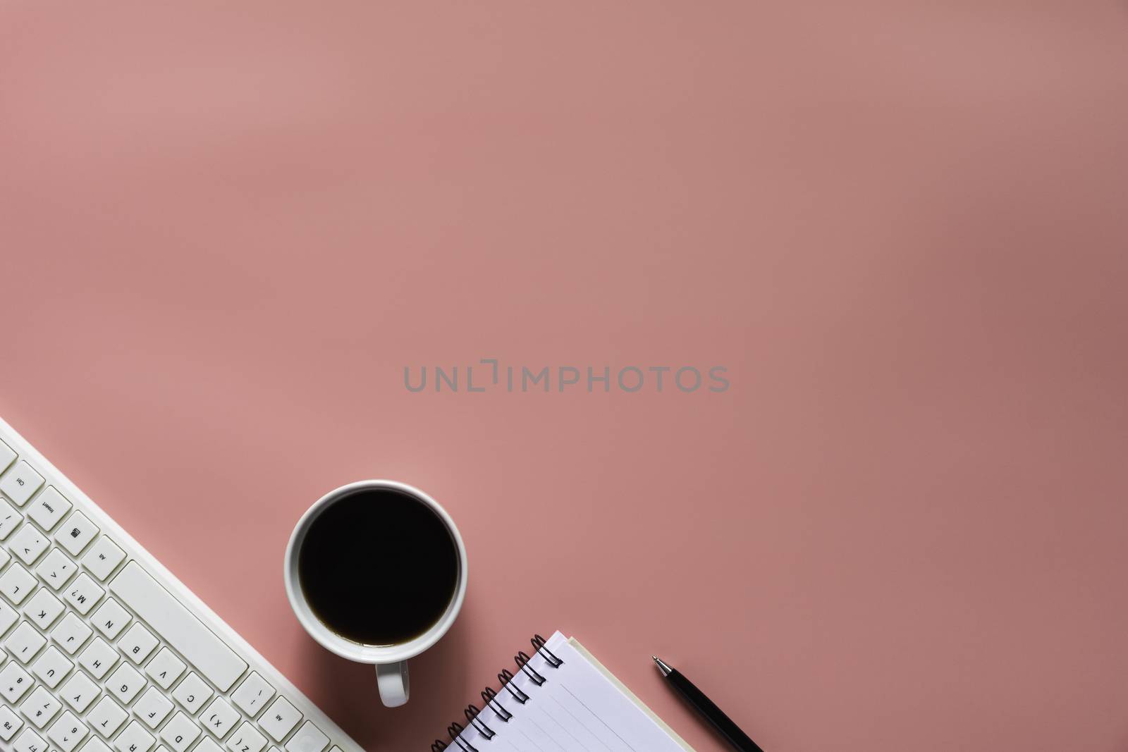 Top view of coffee with notebook and other supplies on pink background and copy space for insert text.