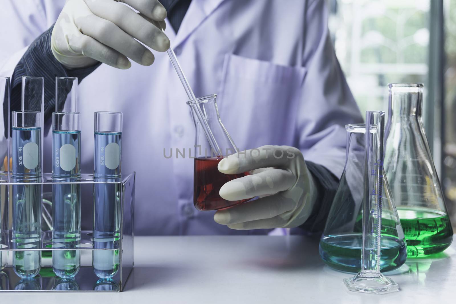 Researcher with glass laboratory chemical test tubes with liquid for analytical , medical, pharmaceutical and scientific research concept.