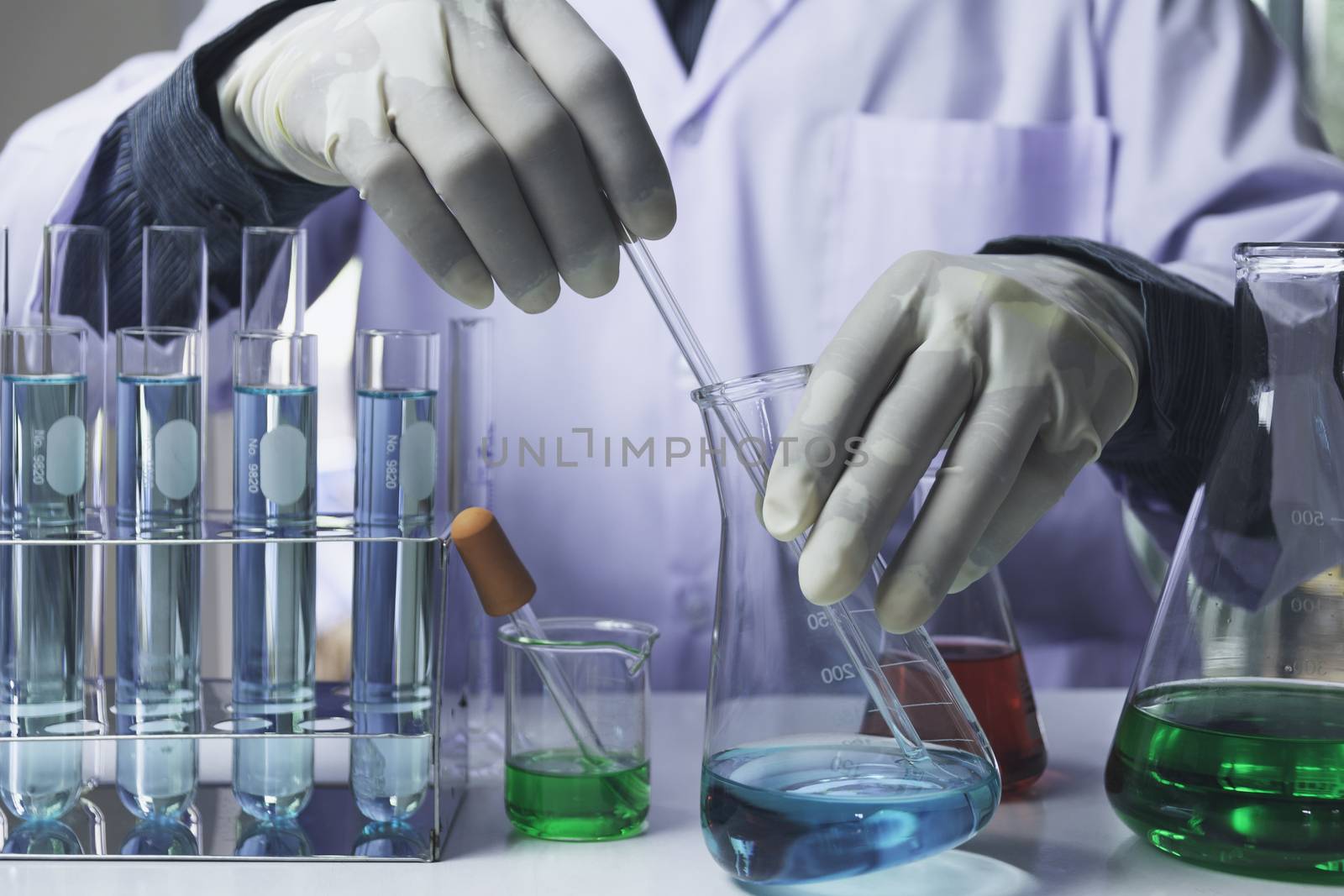 Researcher with glass laboratory chemical test tubes with liquid for analytical , medical, pharmaceutical and scientific research concept.