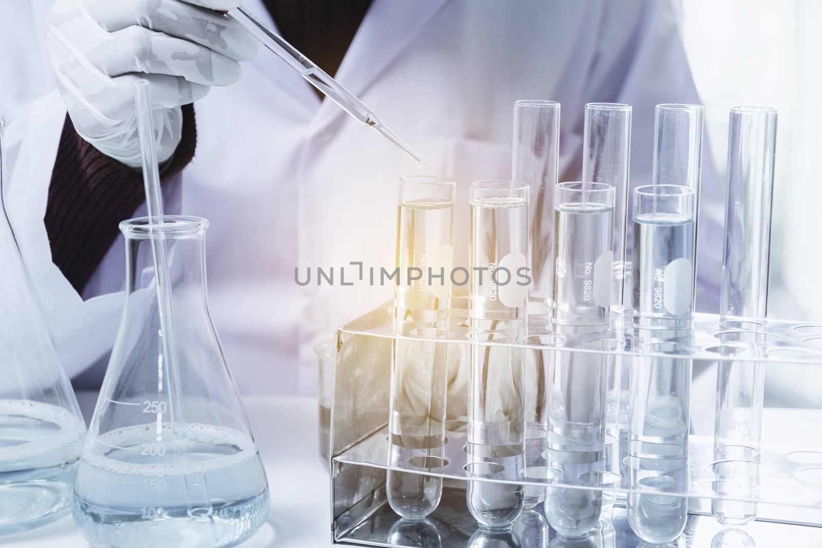 Researcher with glass laboratory chemical test tubes with liquid by kirisa99