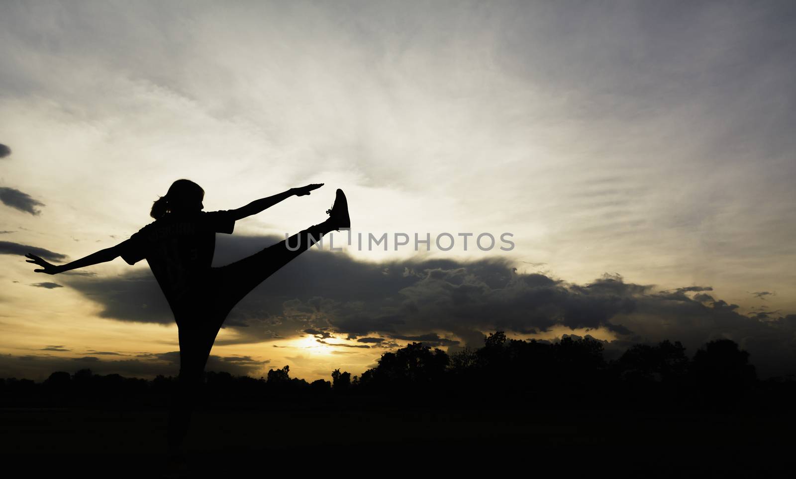 Silhouette of young woman practicing yoga outdoor. Female happiness. Sport and healthy concept. 