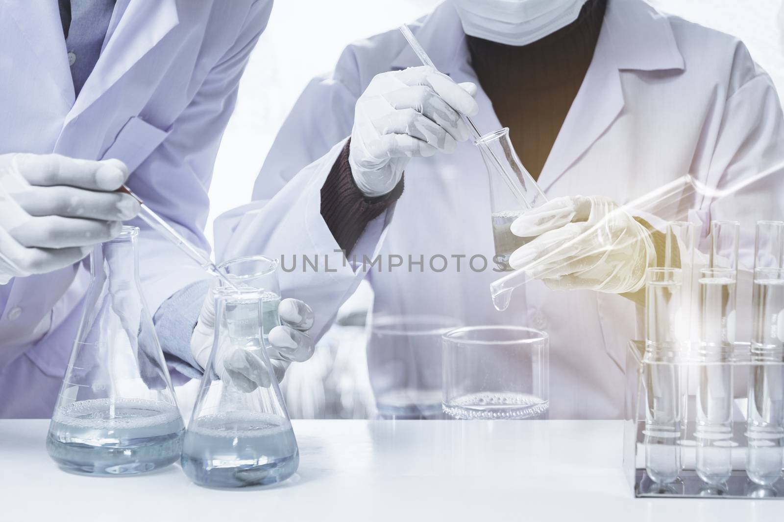 Researcher with glass laboratory chemical test tubes with liquid by kirisa99