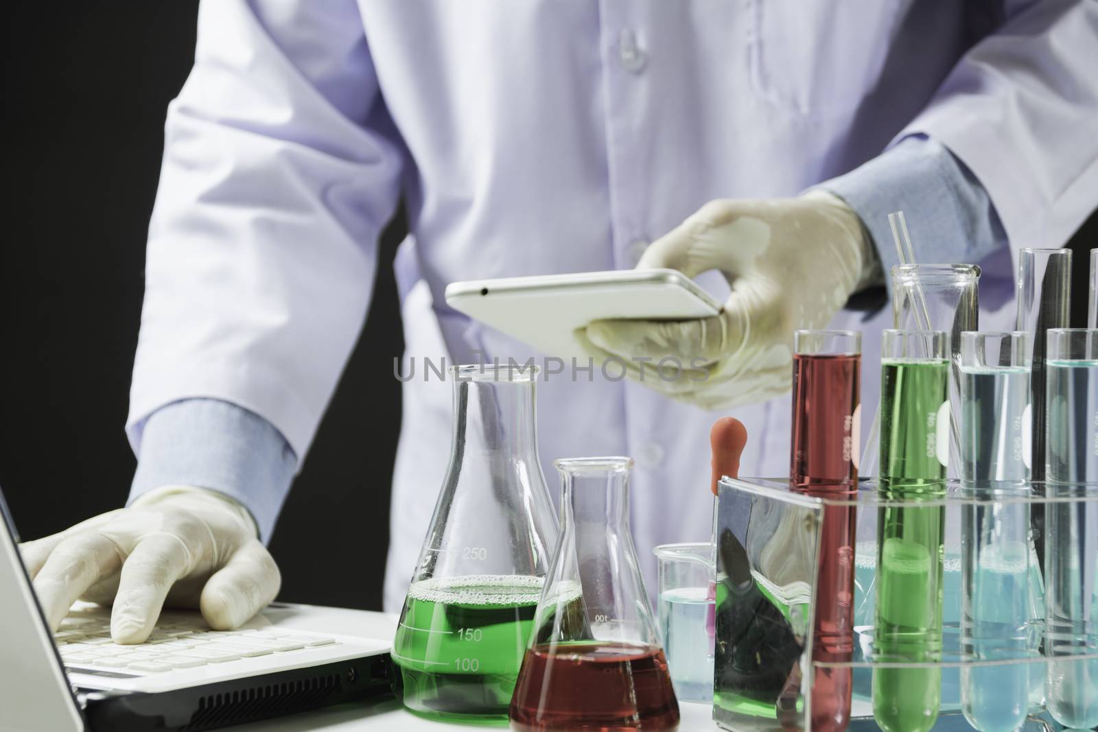 Researcher with glass laboratory chemical test tubes with liquid for analytical , medical, pharmaceutical and scientific research concept.