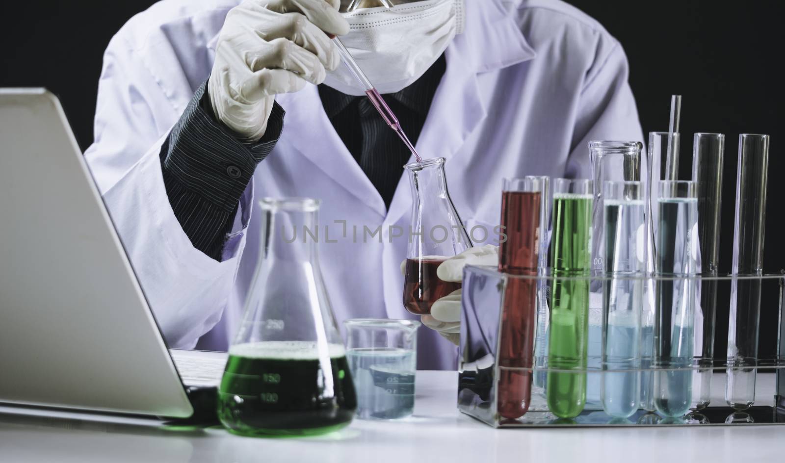 Researcher with glass laboratory chemical test tubes with liquid for analytical , medical, pharmaceutical and scientific research concept.