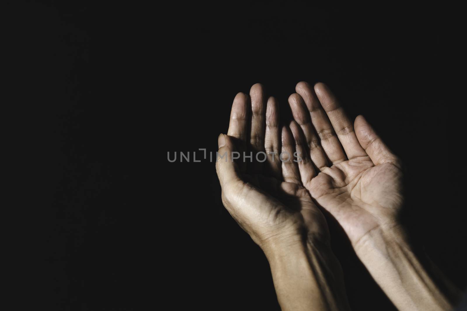 Hand of man while praying for religion. Concept peace and life. by kirisa99