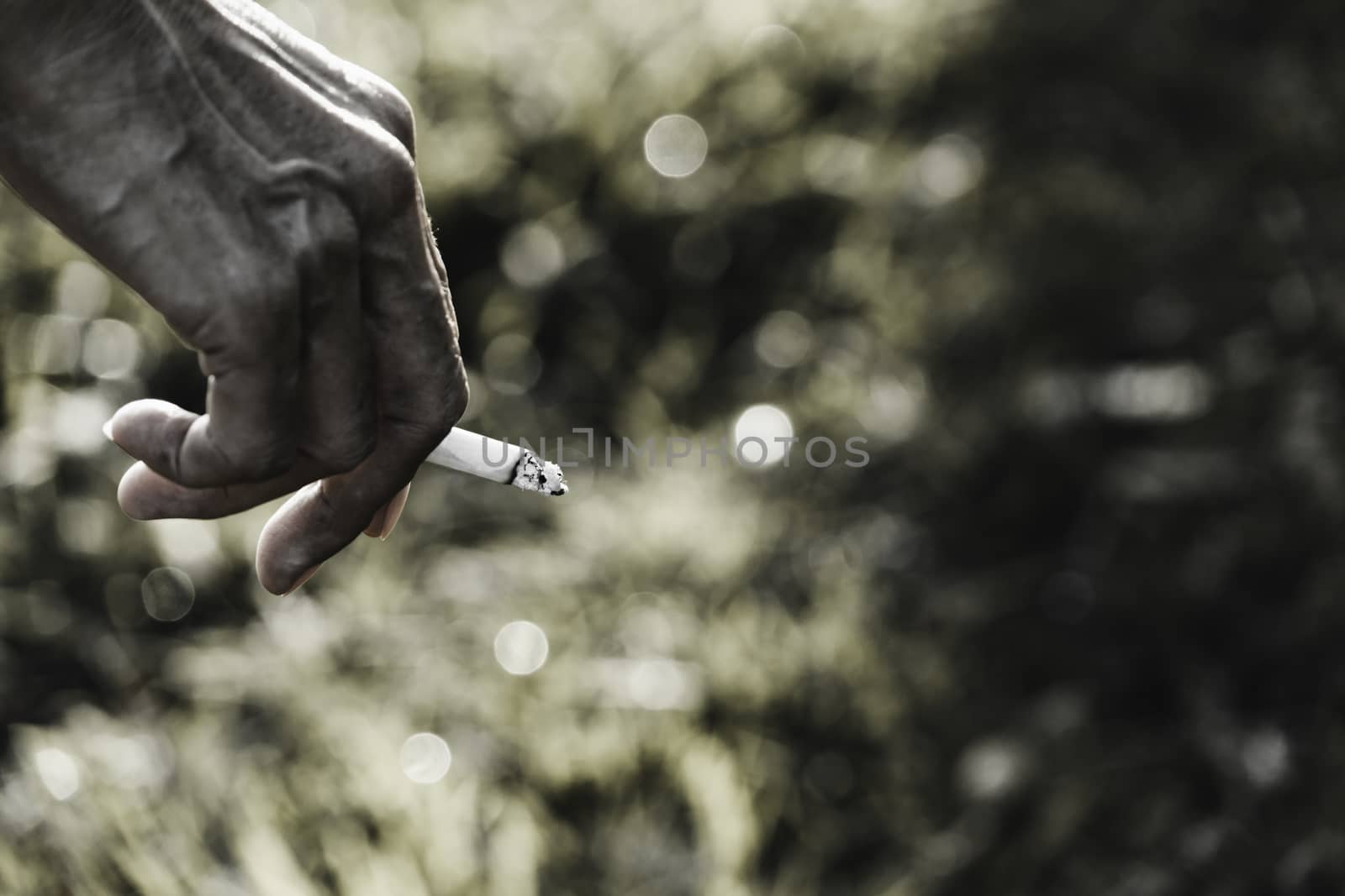 Hand holding a cigarette. A man smoking a cigarette and copy space for insert text.