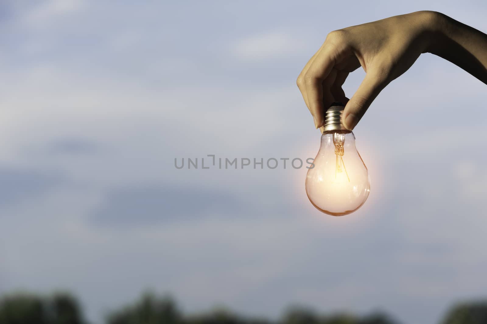 Innovation and energy concept of hand hold a light bulb and copy by kirisa99