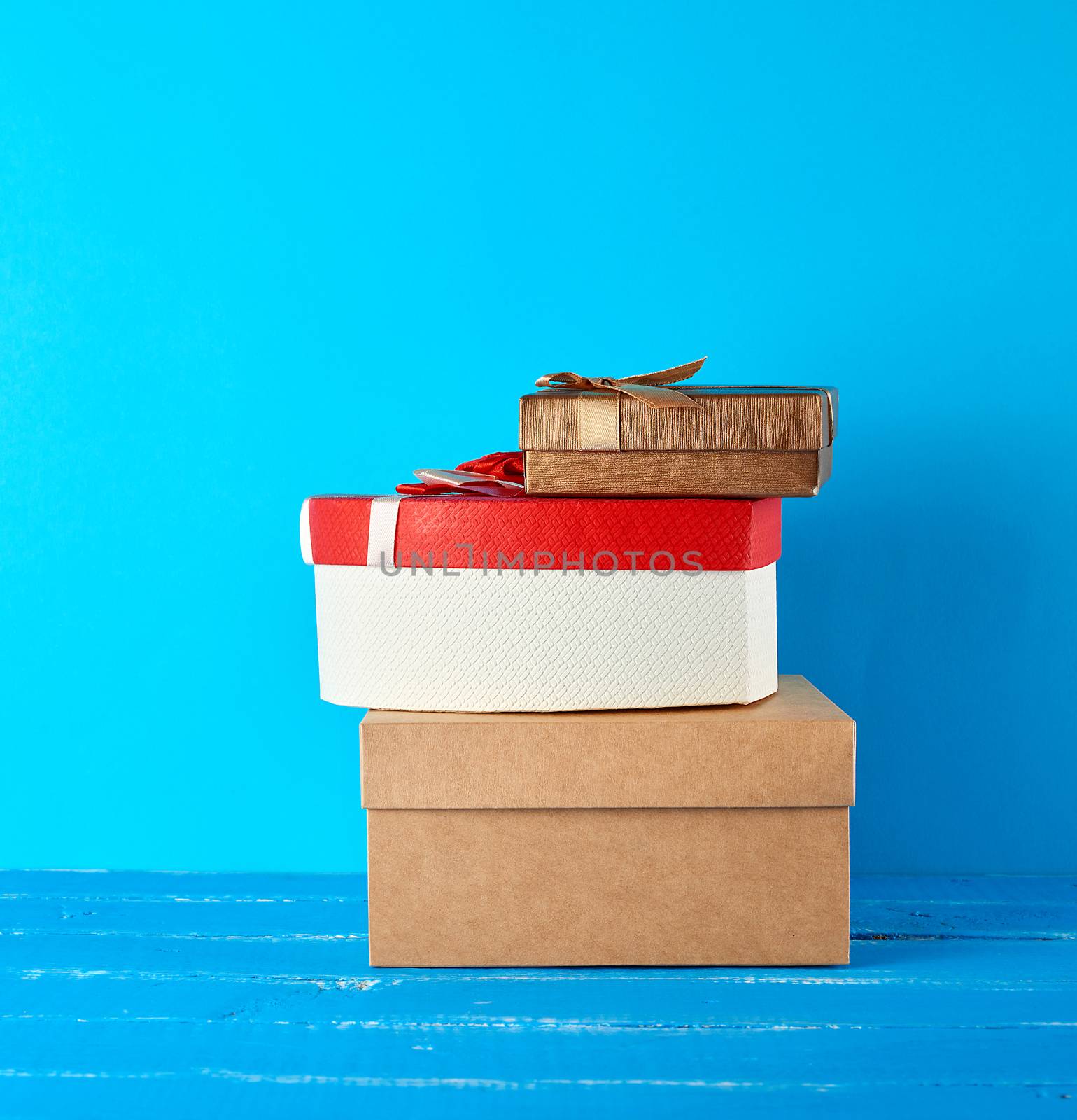 stack of various cardboard boxes on a blue background, festive backdrop