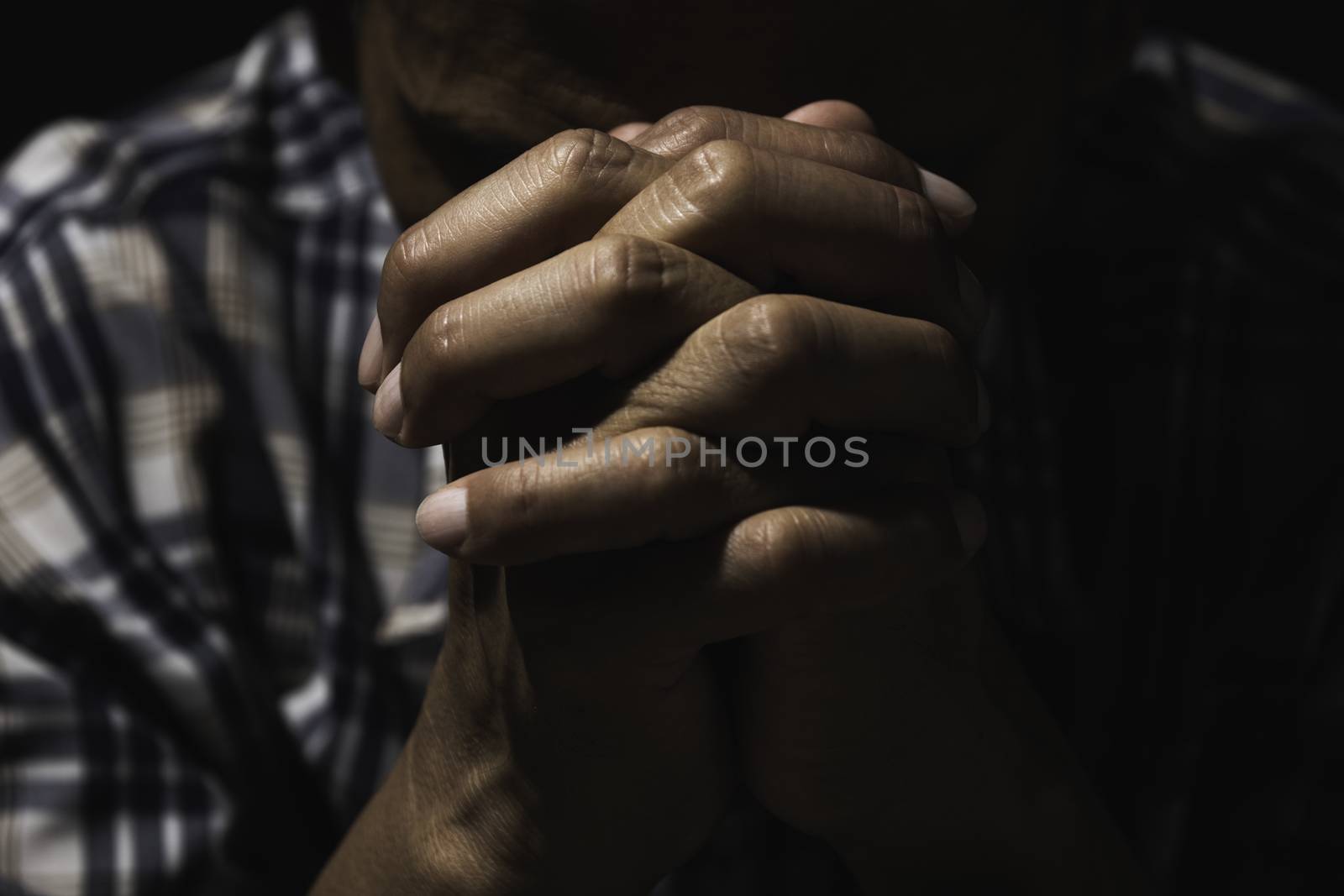 Hand of man while praying for religion. Concept peace and life. by kirisa99