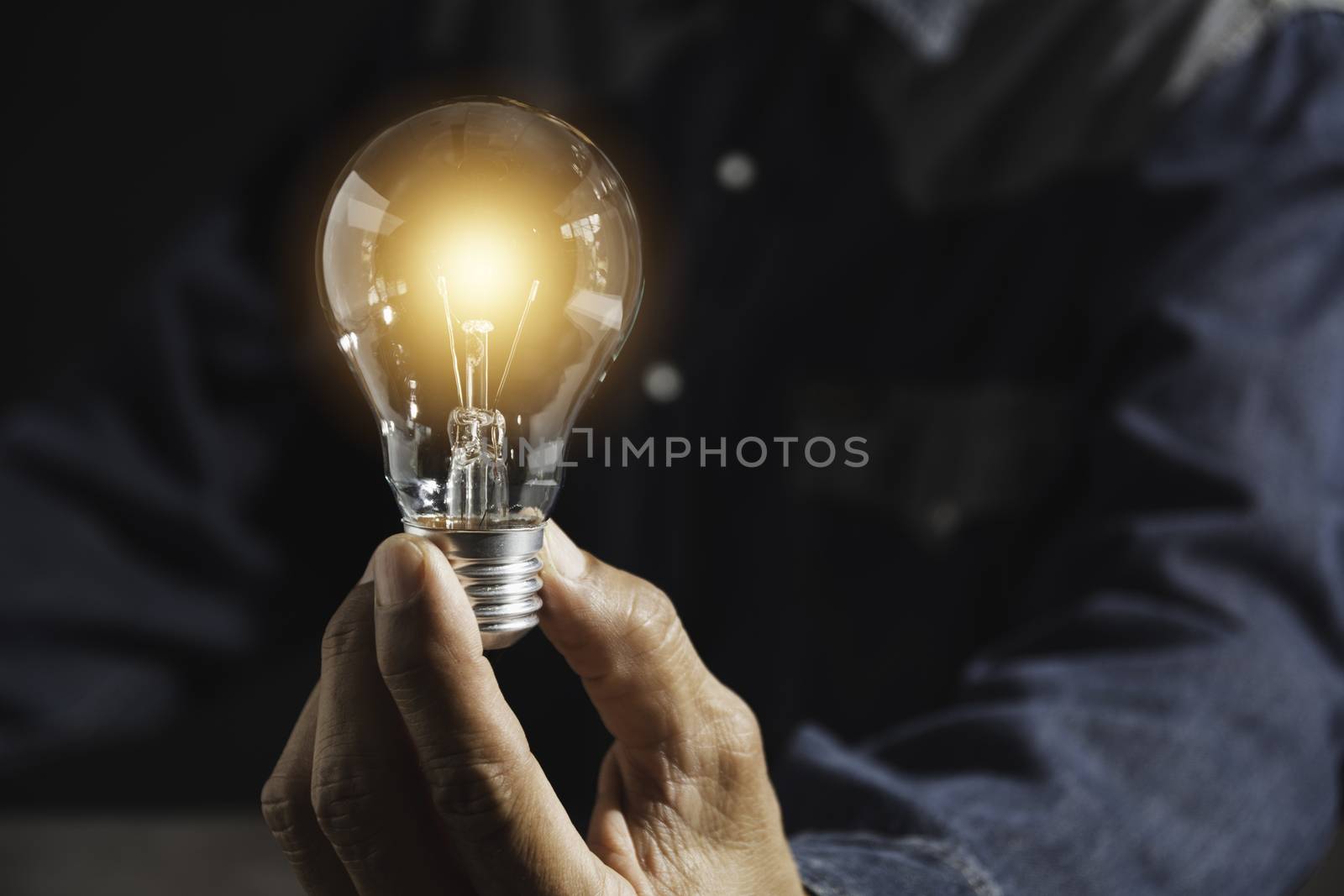 Hand of male holding a light bulb and copy space for accounting, ideas and creative concept.