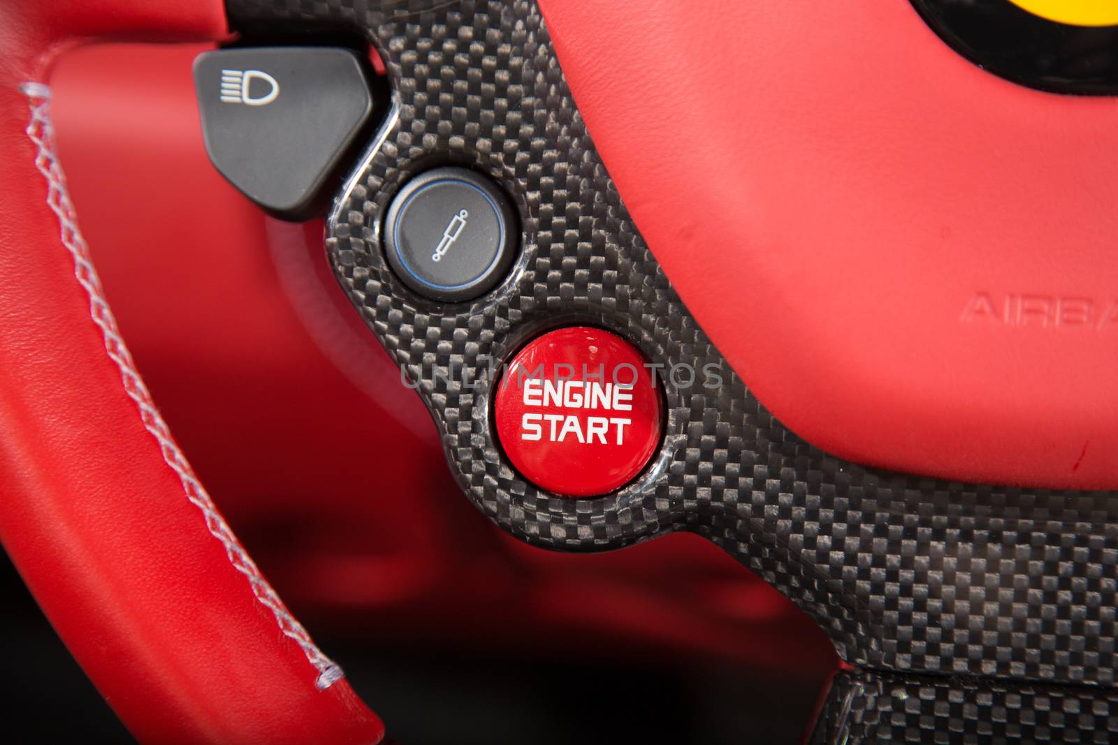 Close up of start engine button on red leather car steering wheel