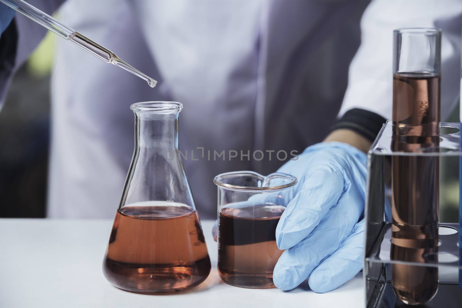 Researcher with glass laboratory chemical test tubes with liquid by kirisa99