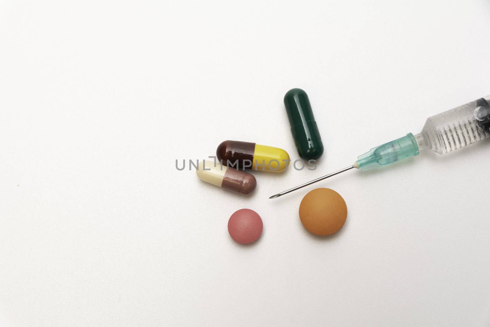 pharmaceuticals antibiotics pills, medicine pills, and capsules and syringe on white background.