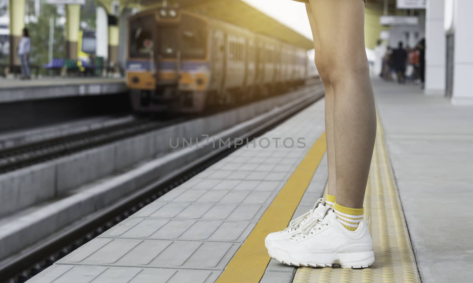 Woman standing and waiting in train station. Travel concept.