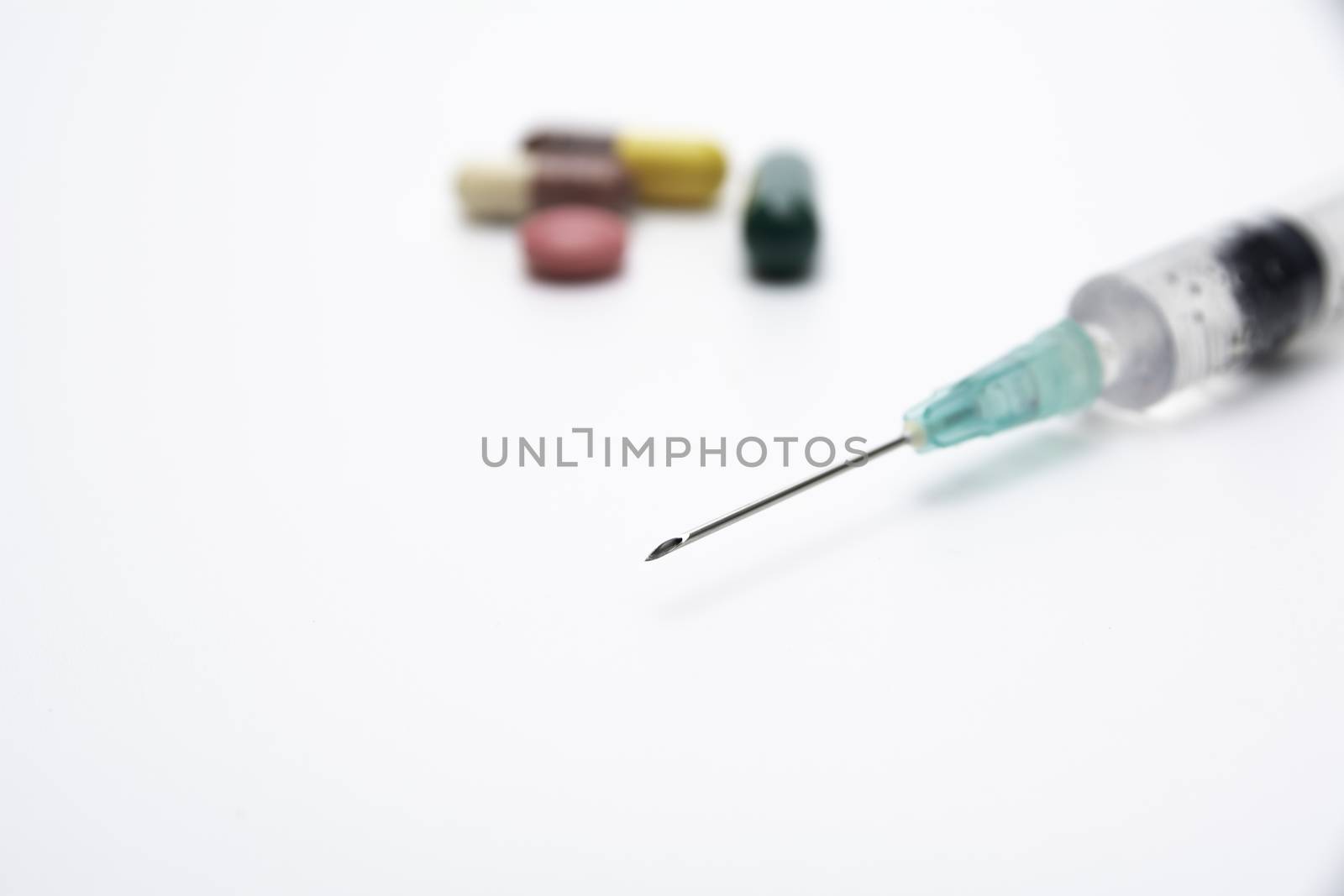 pharmaceuticals antibiotics pills, medicine pills, and capsules and syringe on white background.