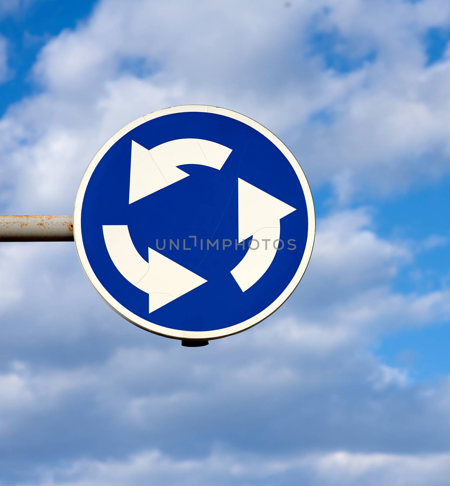 round metal blue road sign circle motion on sky background