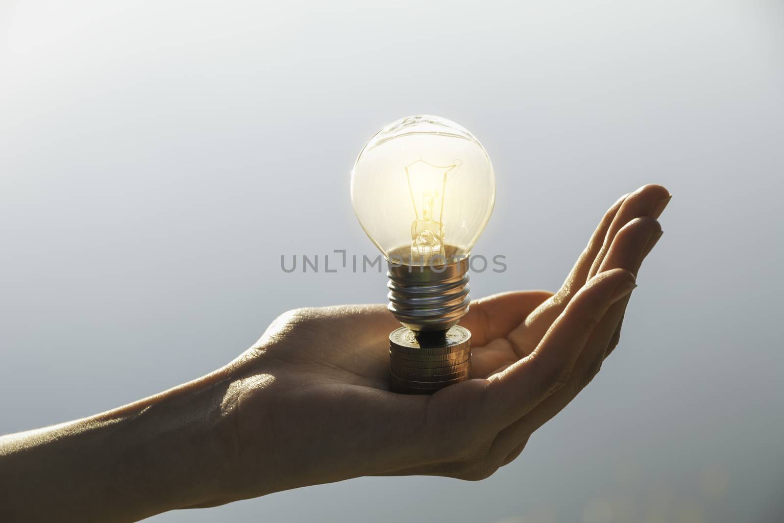 Hand of male holding a light bulb and copy space for energy, ide by kirisa99