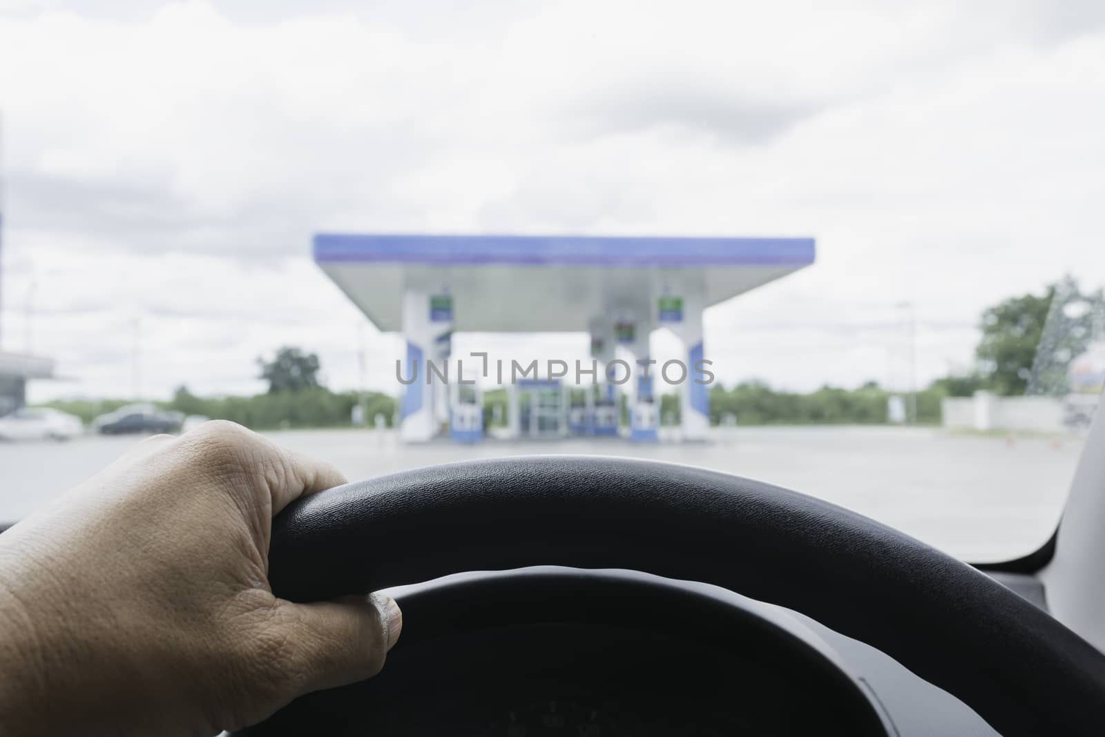 A Driver with Gas fuel station and clouds and blue sky.