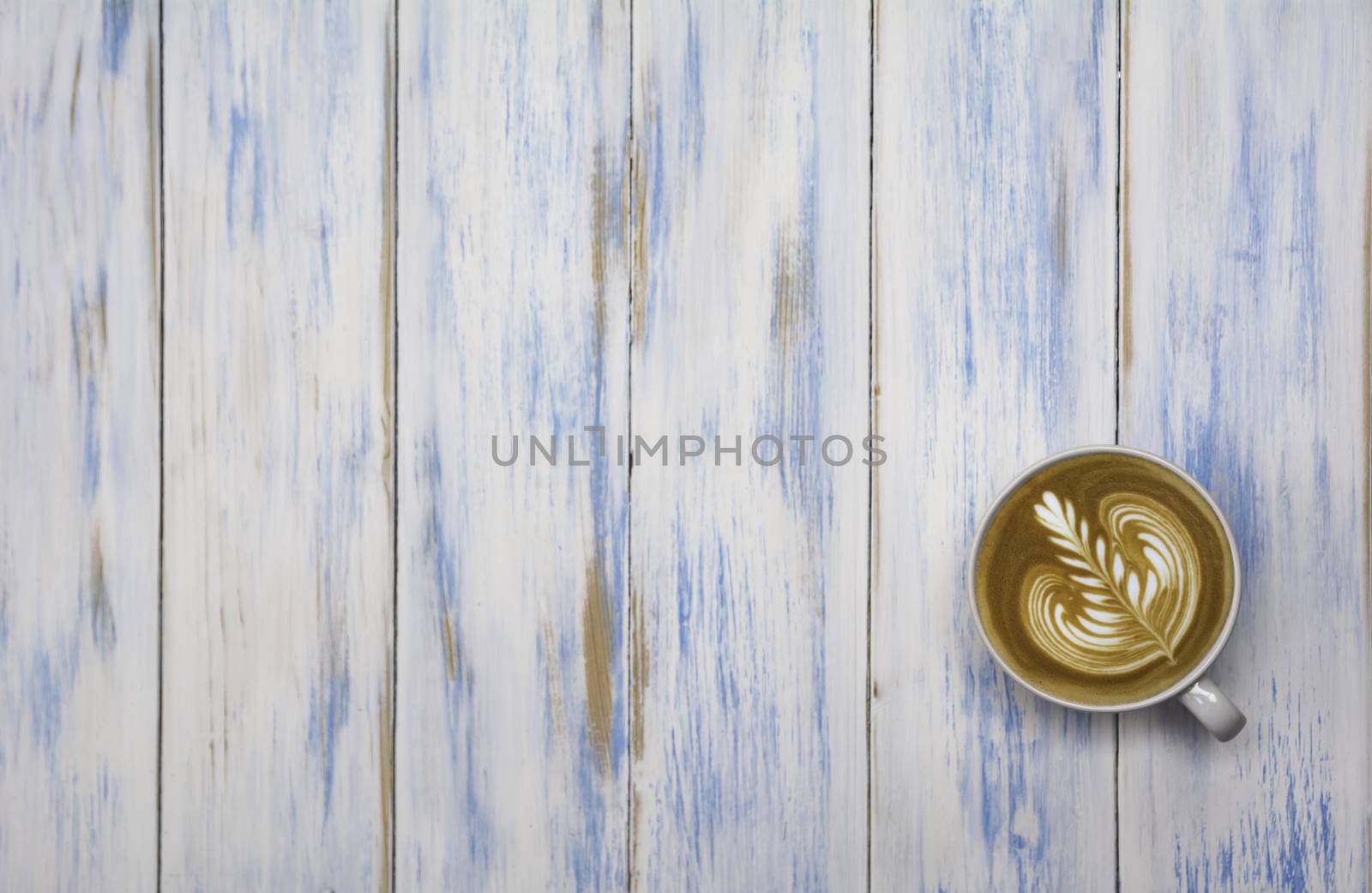 A cup of coffee on wooden table. Top view of coffee latte art with copy space. Drink and art concept.