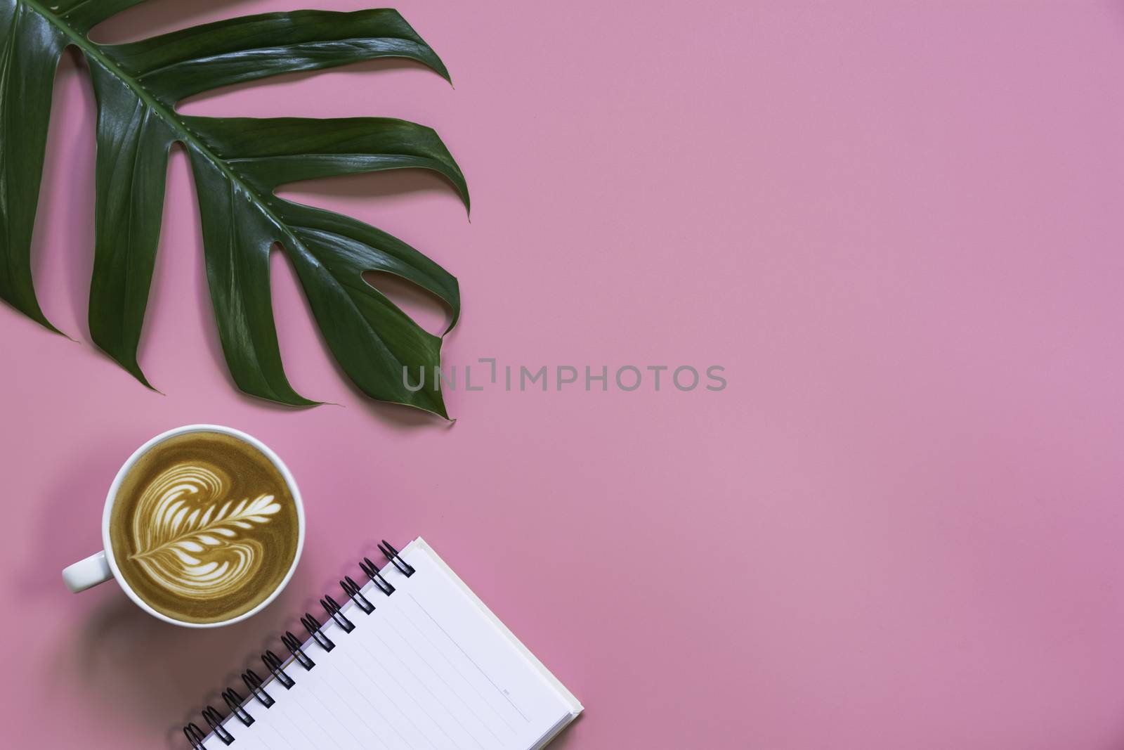 A cup of coffee with note and copy space on pink background. Food and drink concept.