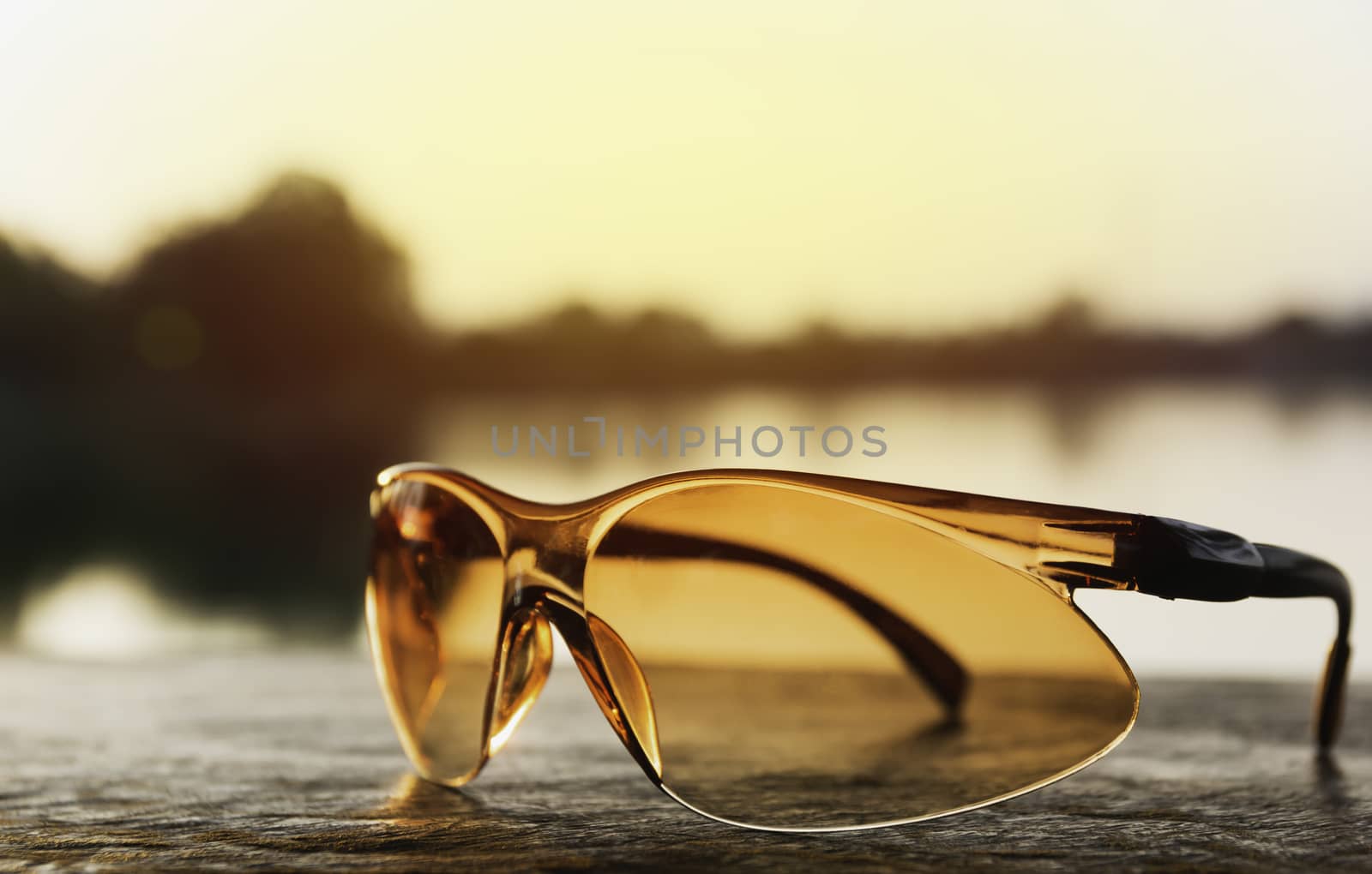 Sunglasses for sports on sunset background. Sport accessory and fashion concept.