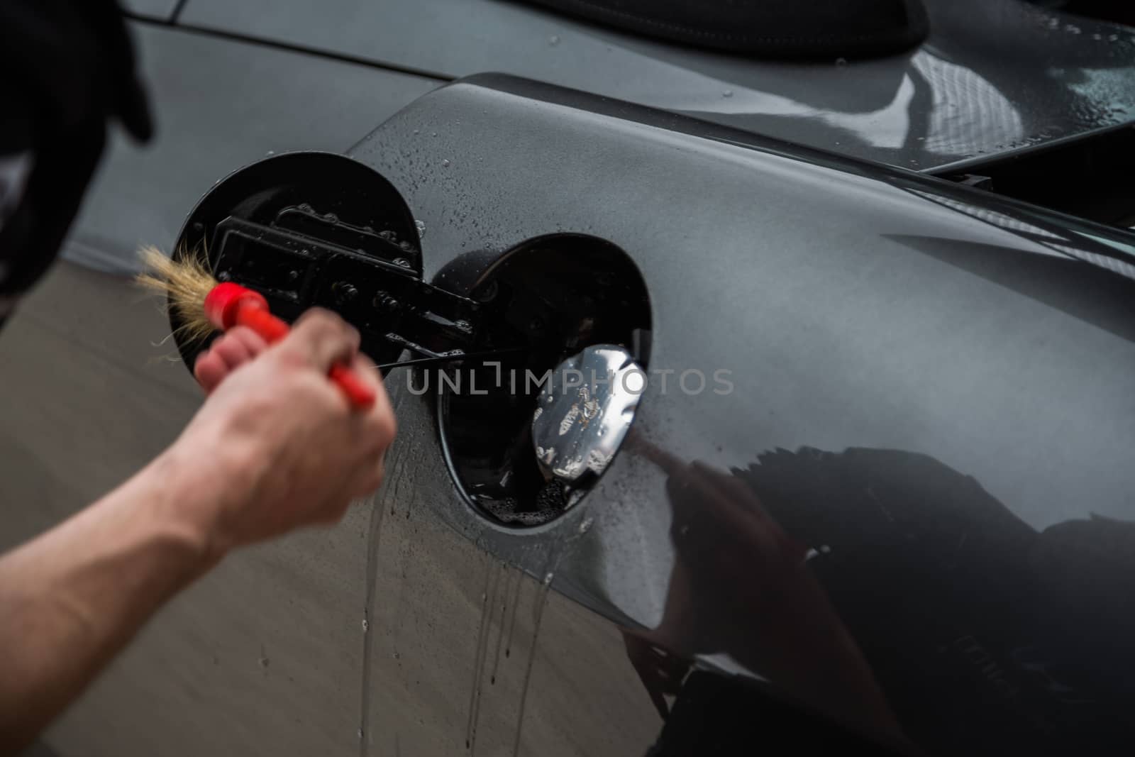 Detailer using a brush on a car during washing by camerarules