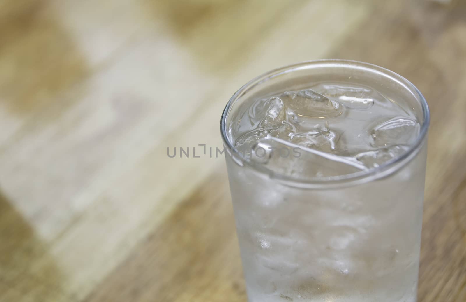 Ice cold water in glass on wooden table with copy space. Drink and healthy concept.