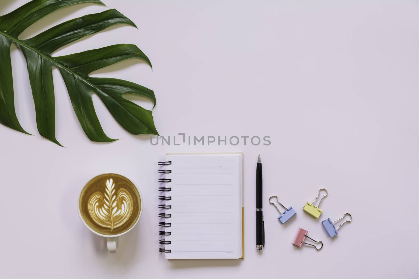 A cup of coffee with note and copy space on white background. Office desk and drink concept.