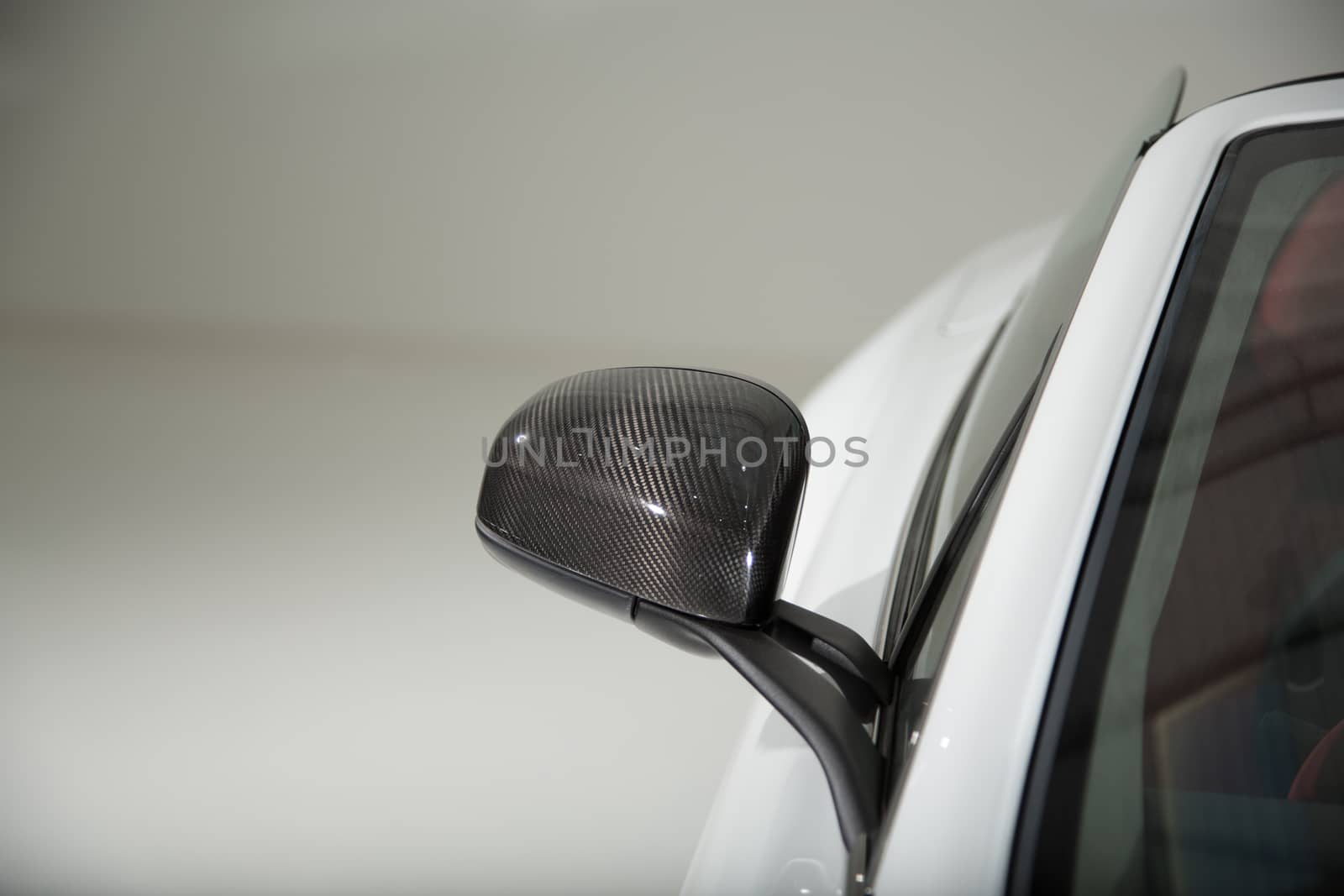 Carbon fibre mirror car on white sports car by camerarules