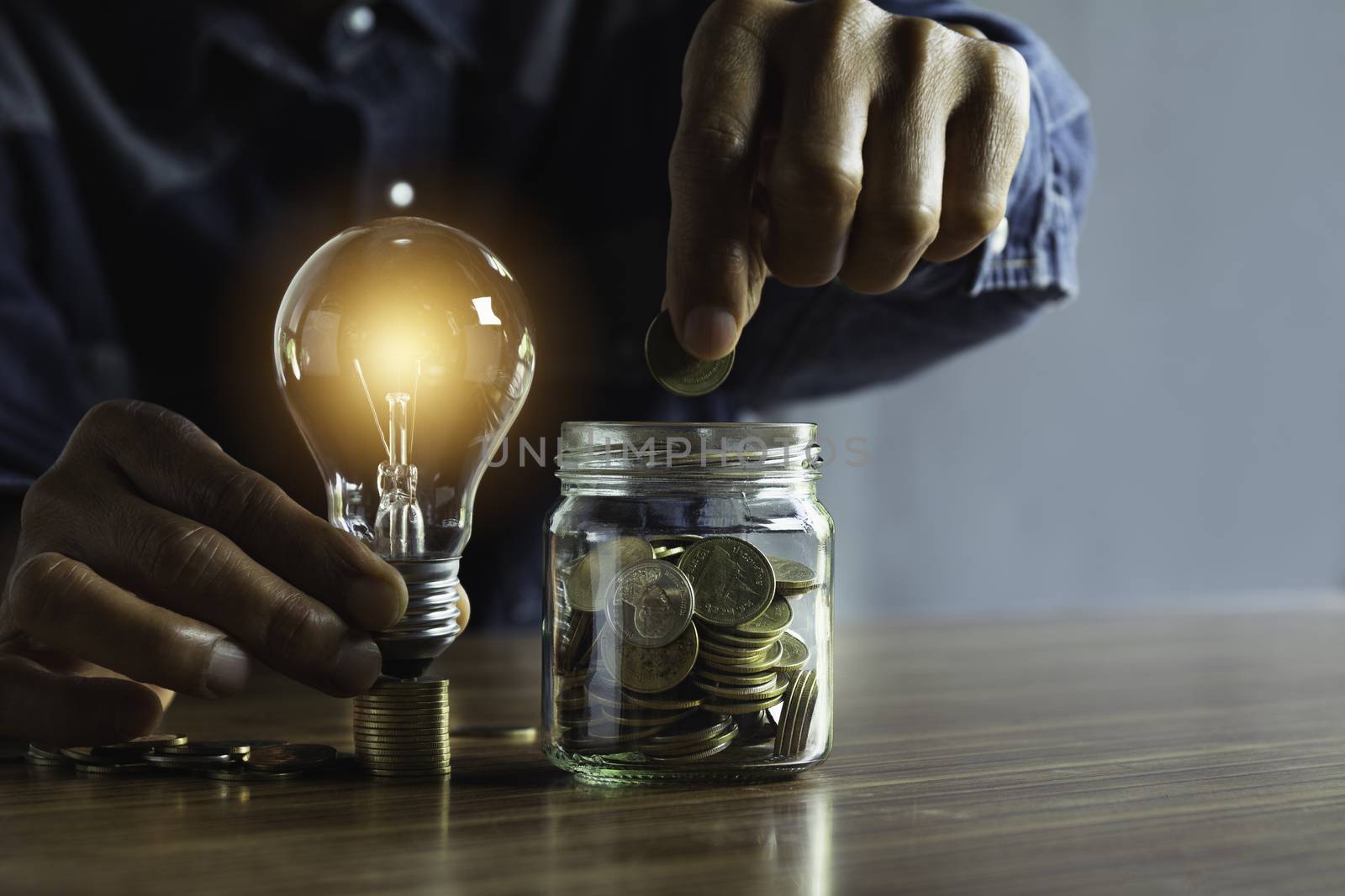 Hand of male holding a light bulb with coins money and copy spac by kirisa99