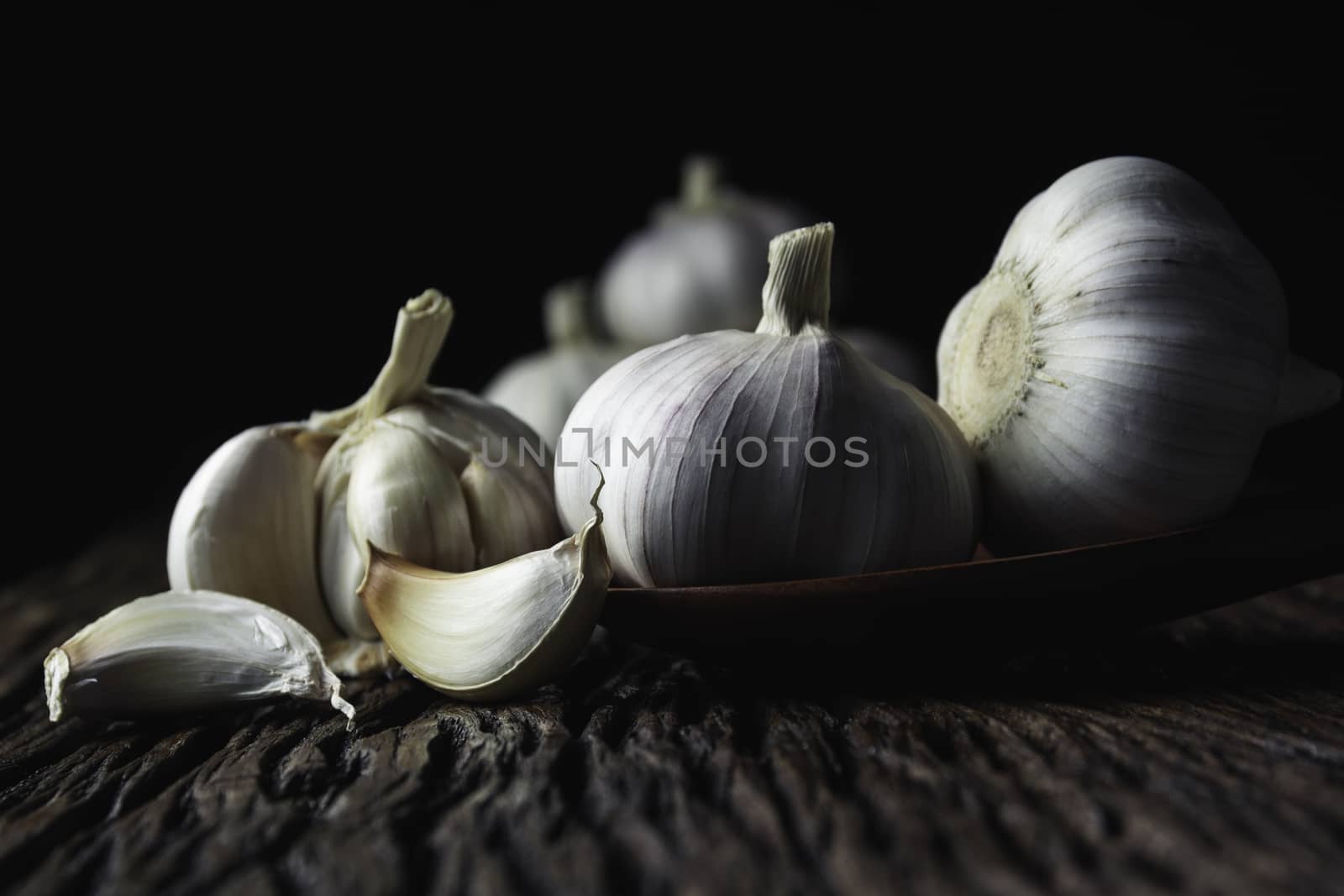 Fresh white garlic on wooden table with black background. Food a by kirisa99