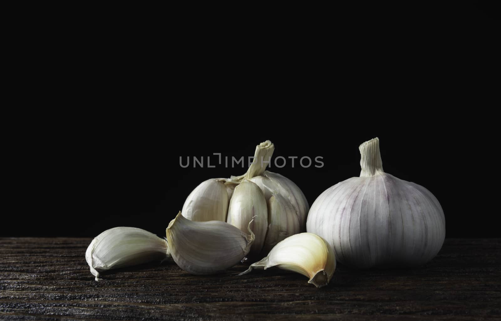 Fresh white garlic on wooden table with black background. Food a by kirisa99