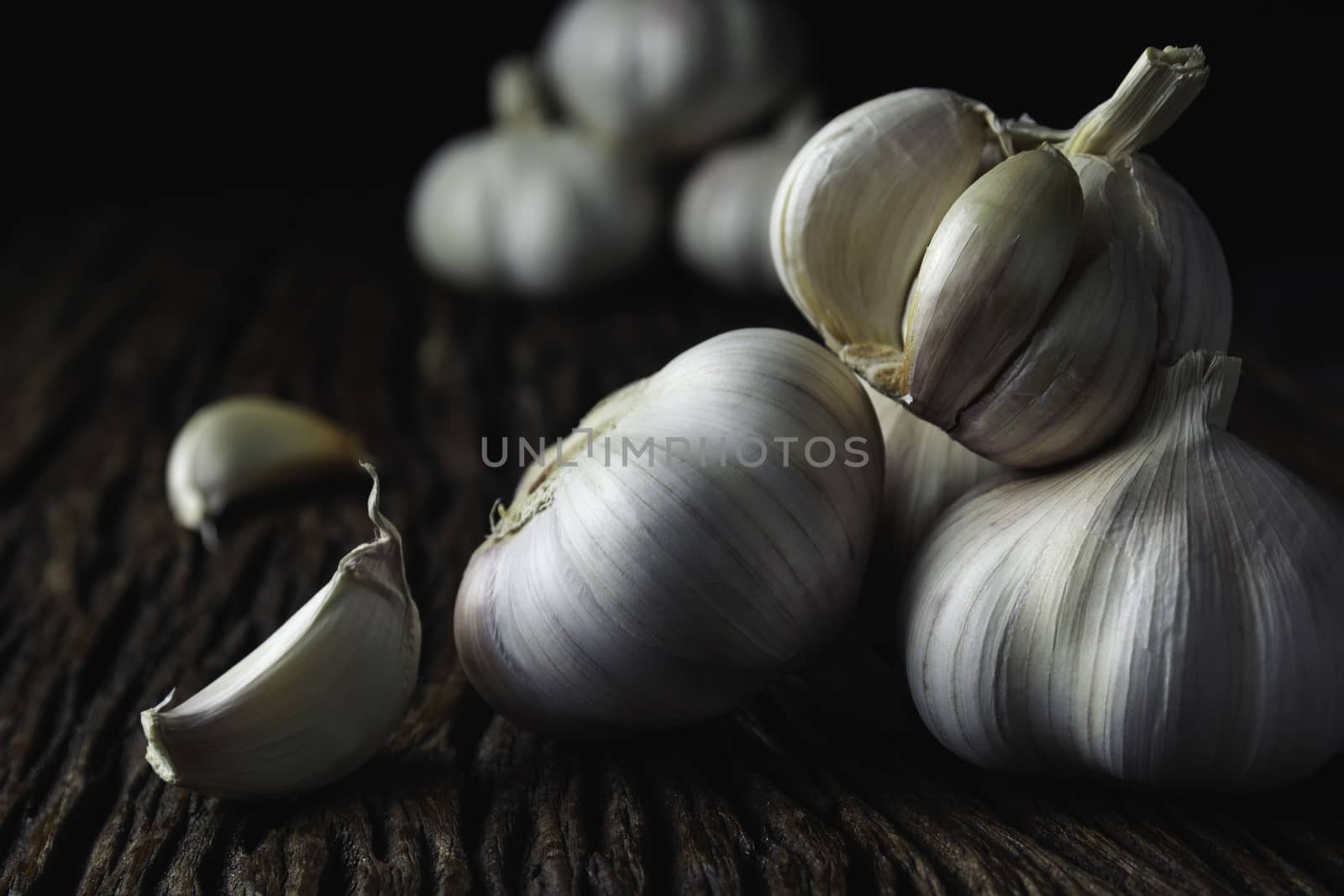 Fresh white garlic on wooden table with black background. Food a by kirisa99